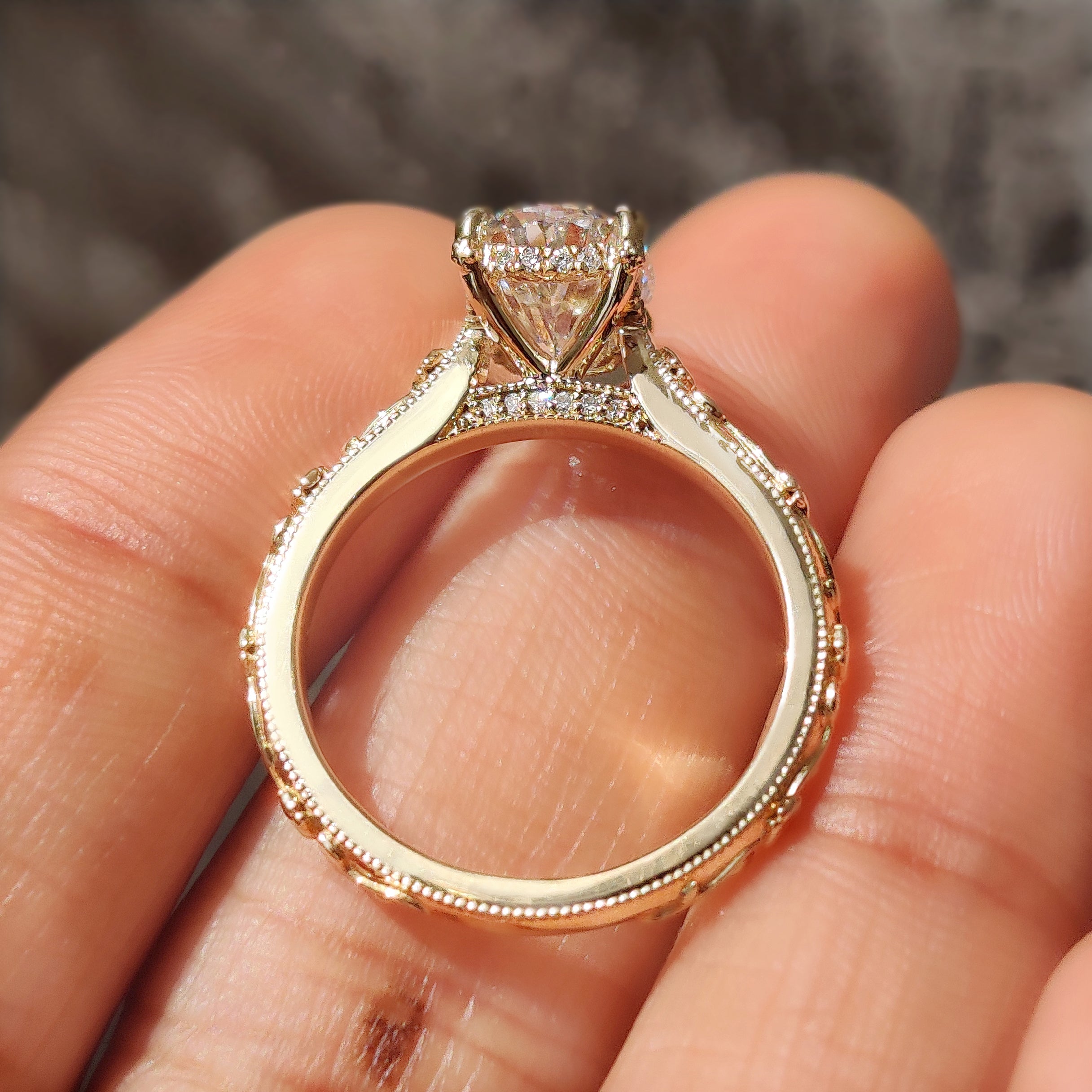 Round diamond accents on the bridge setting of the ring.
