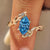 Blue Dutch marquise diamond ring with bypass vine shank in yellow gold.
