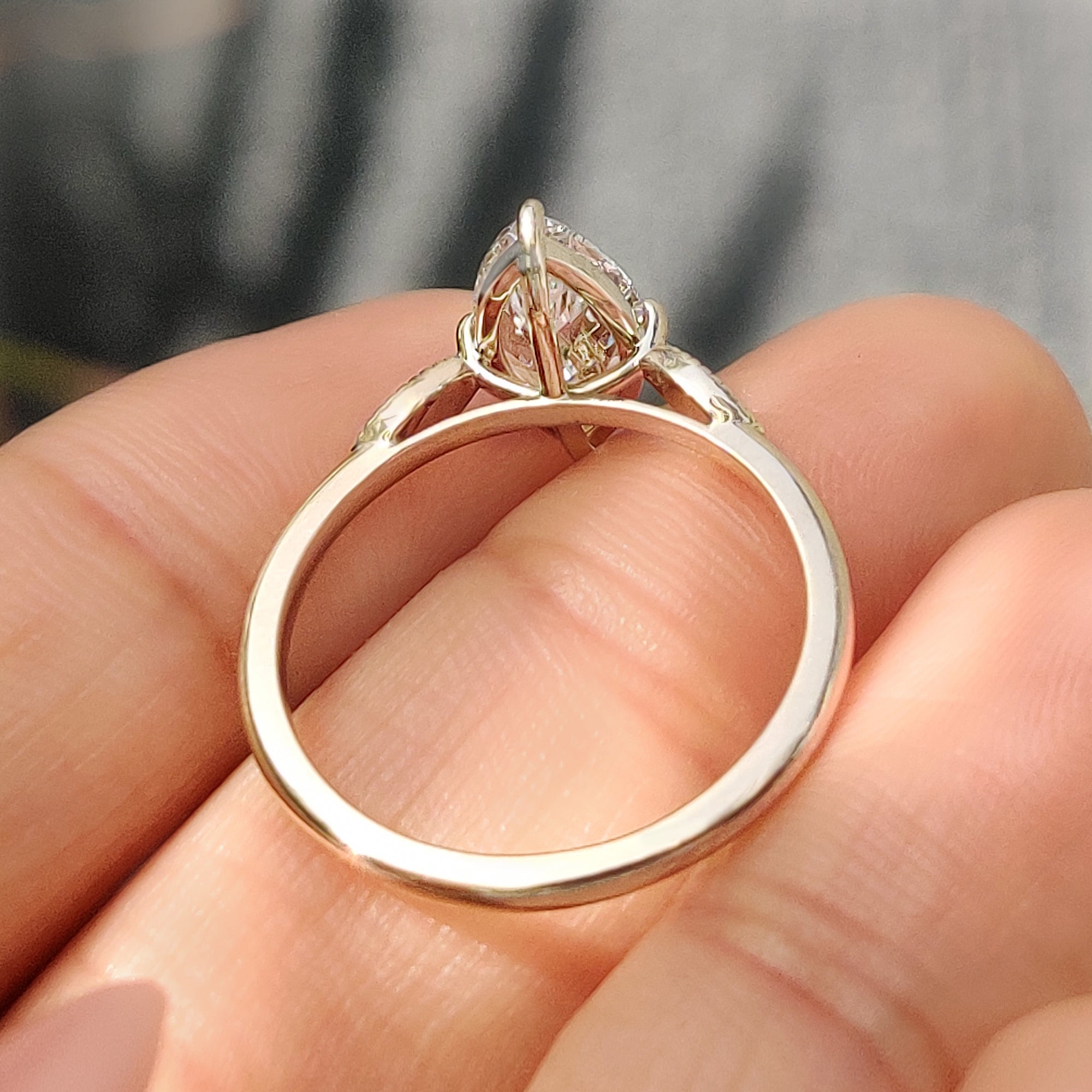 Marquise diamond ring with cathedral setting and round accents.
