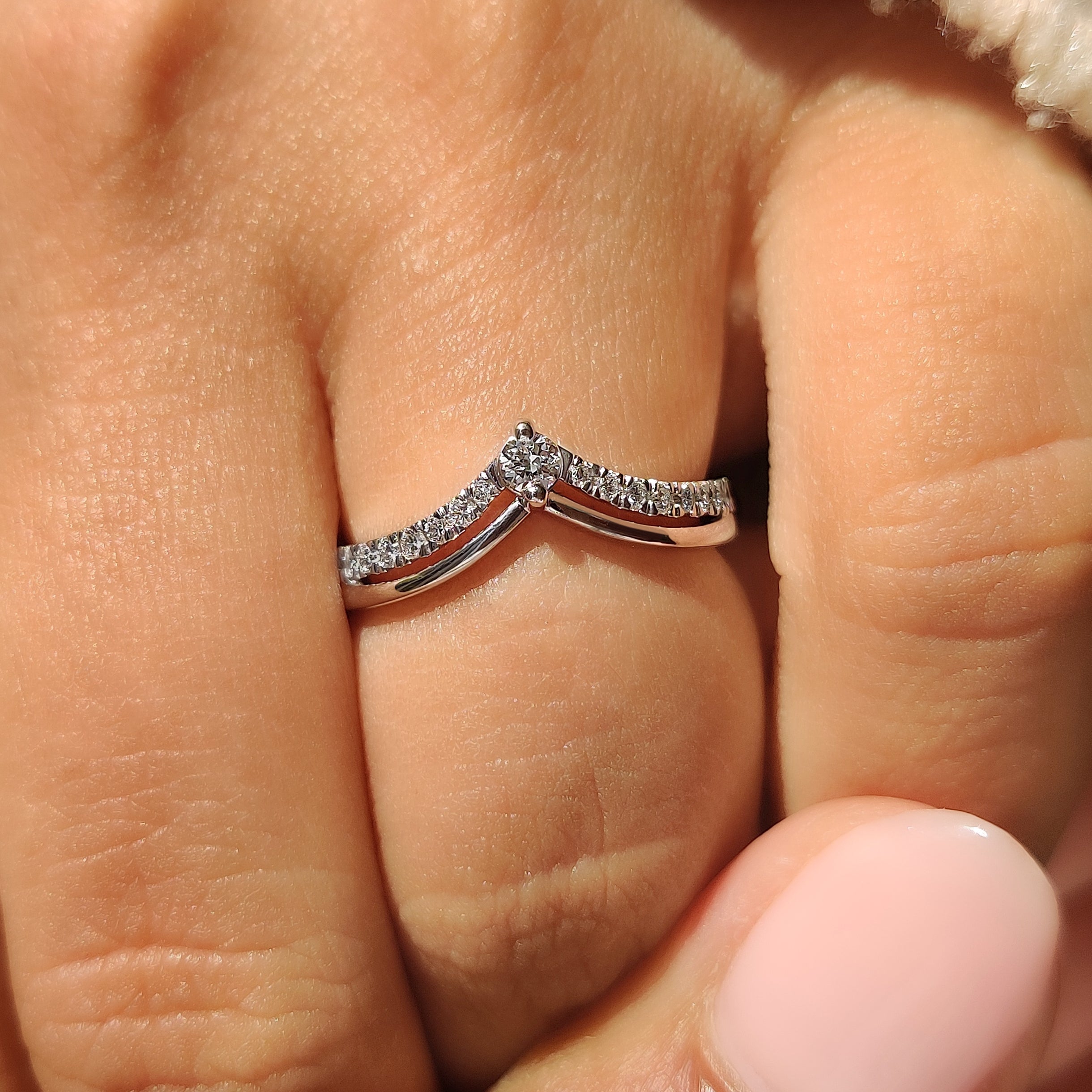 Chevron style wedding band with round diamond accents
