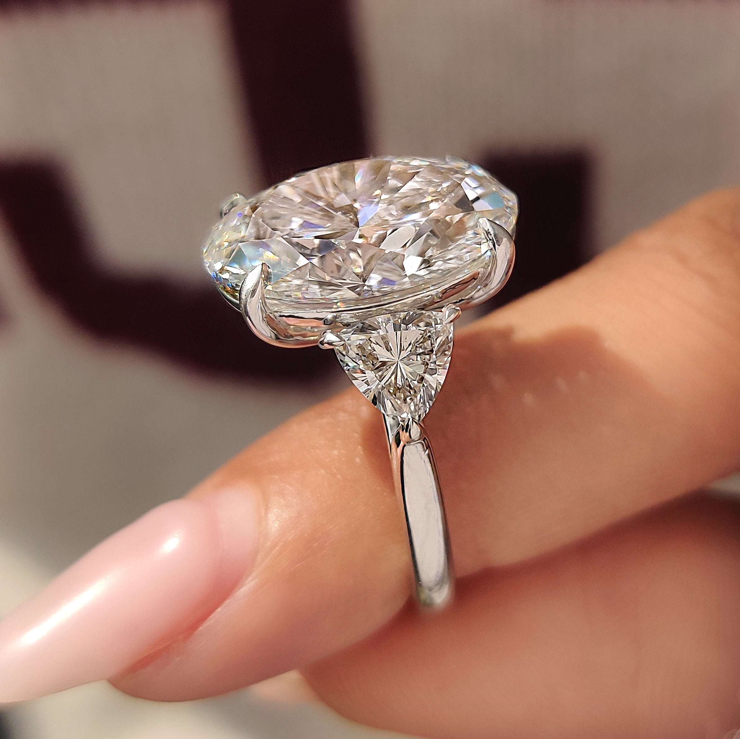 Oval diamond ring with trillion side stone accents
