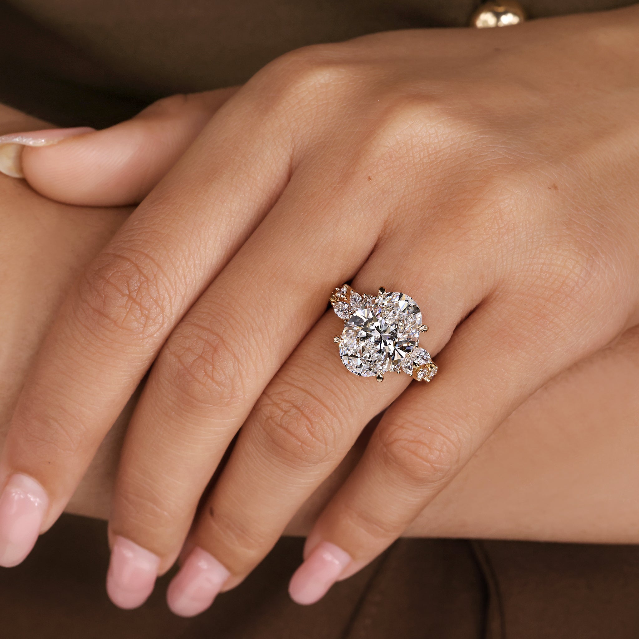 Classic oval cut diamond ring enhanced with marquise and round side stones.
