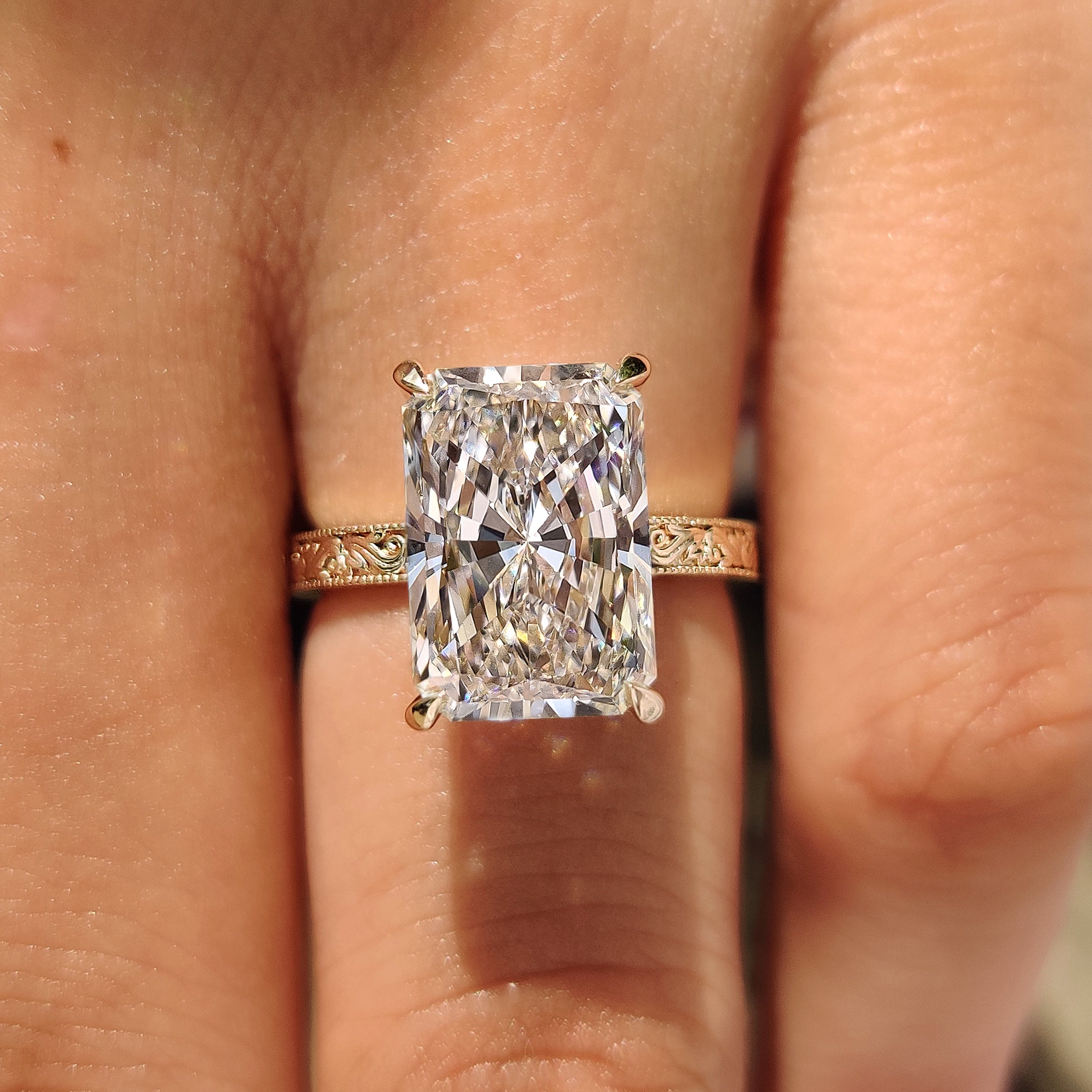 Radiant cut diamond ring with filigree design.

