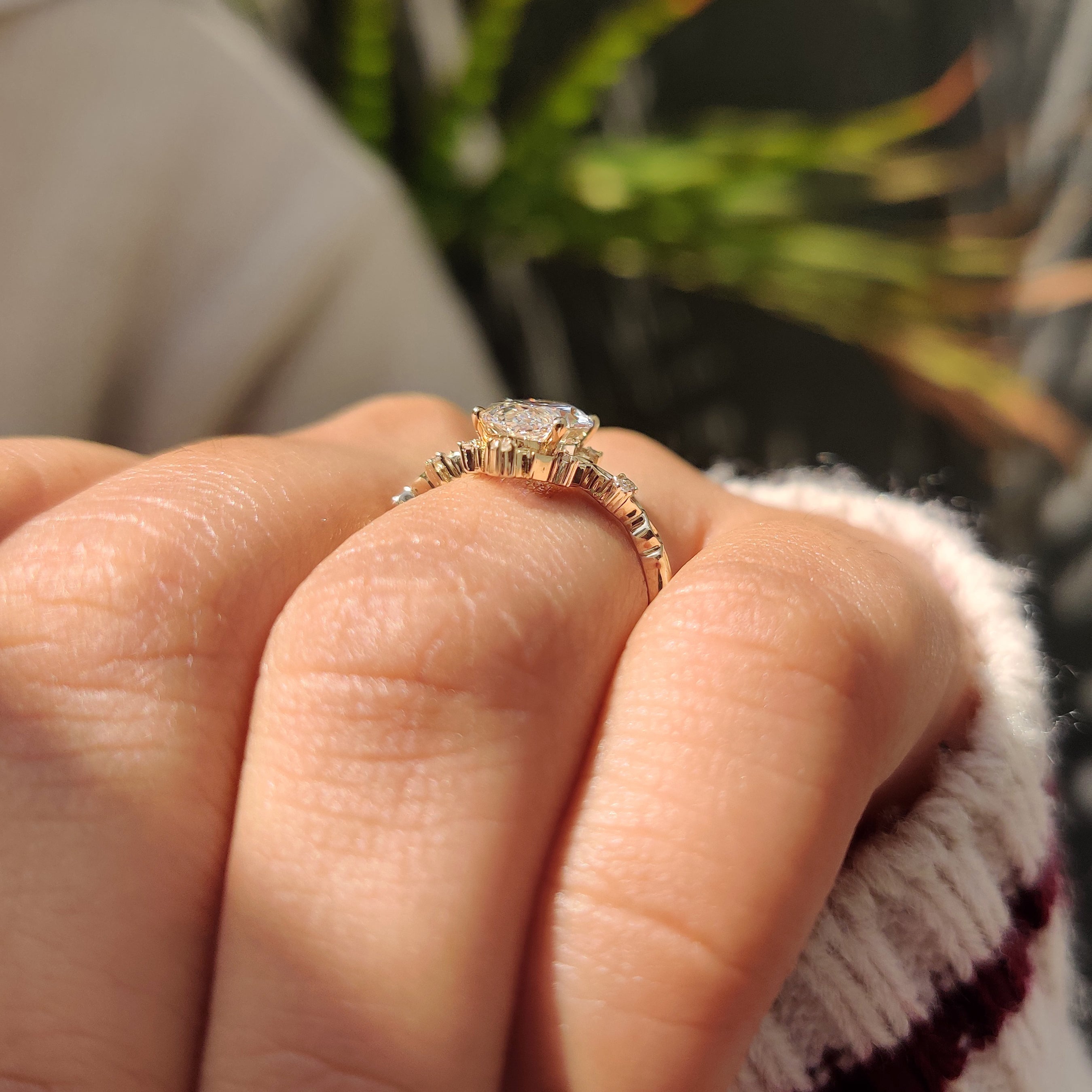 Marquise cut diamond ring with four prongs and accents.
