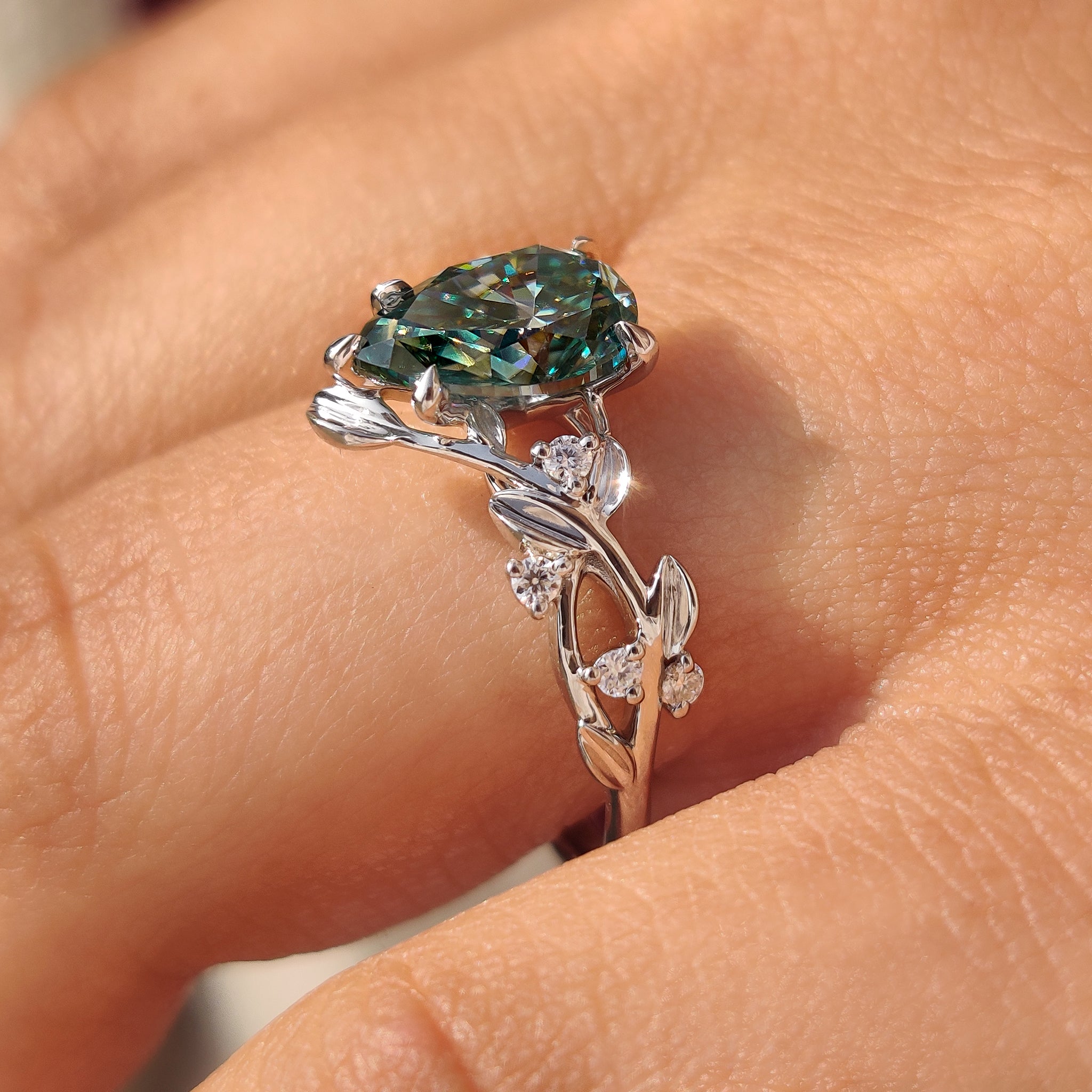 Nature inspired cyan blue pear moissanite ring leaves petals

