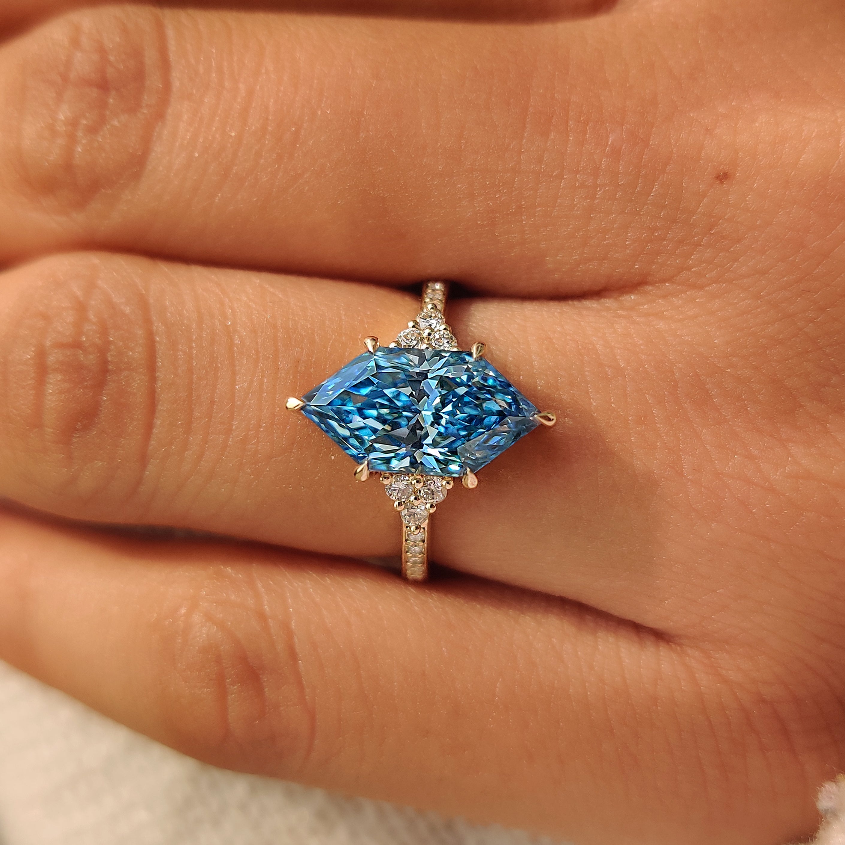Six claw prongs holding a blue Dutch marquise diamond.
