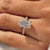 Emerald cut ring with filigree design and milgrain detailing.
