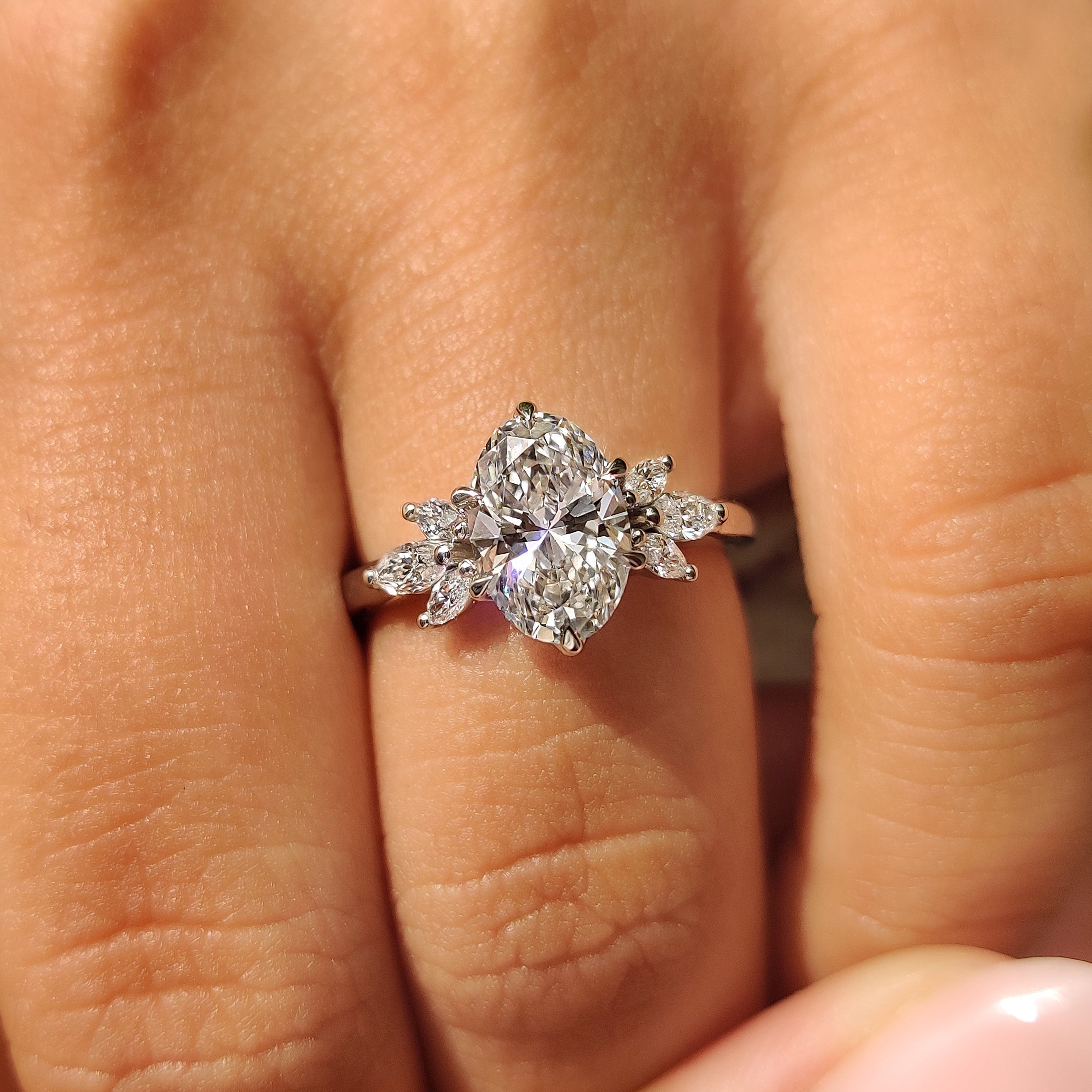 Oval diamond ring with tulip setting and marquise accents
