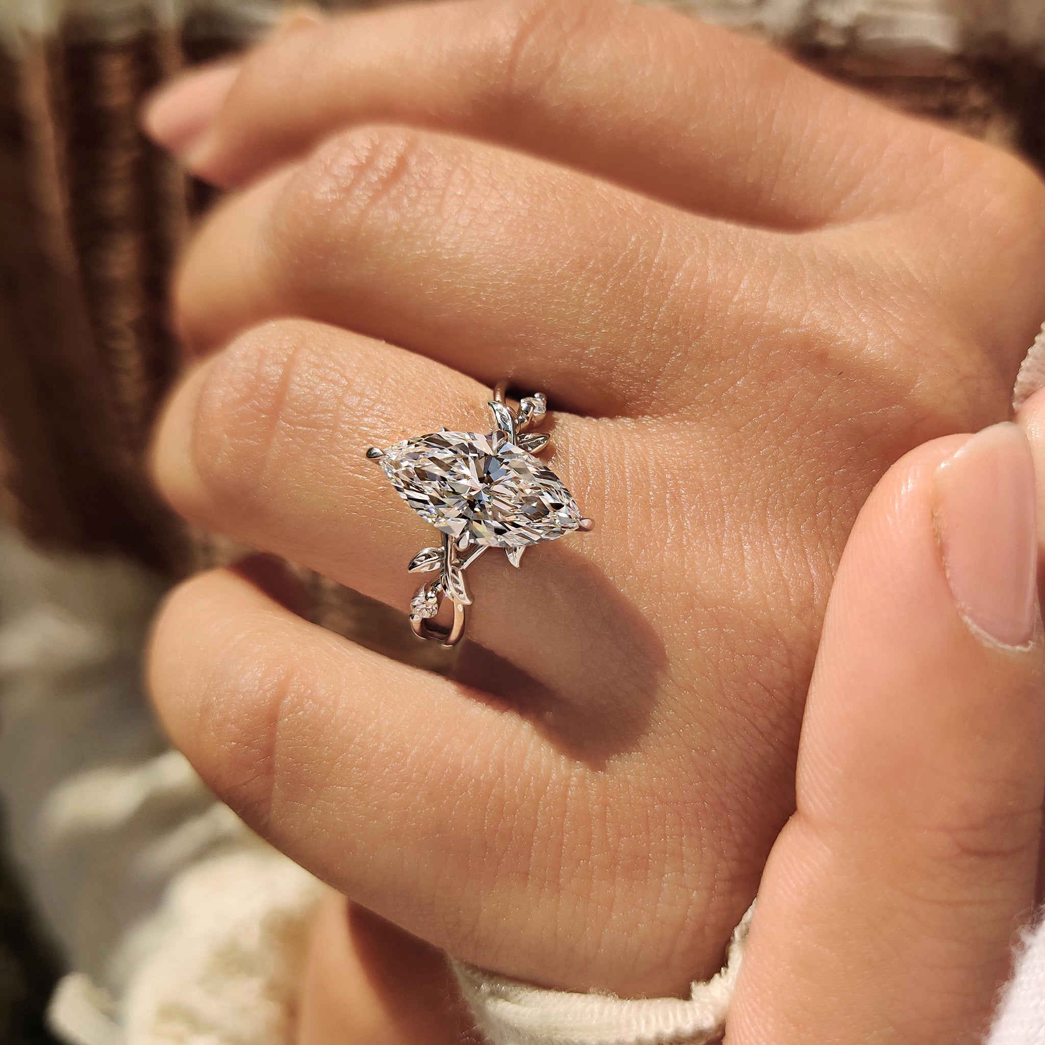 Marquise diamond ring with compass prong and hidden halo.
