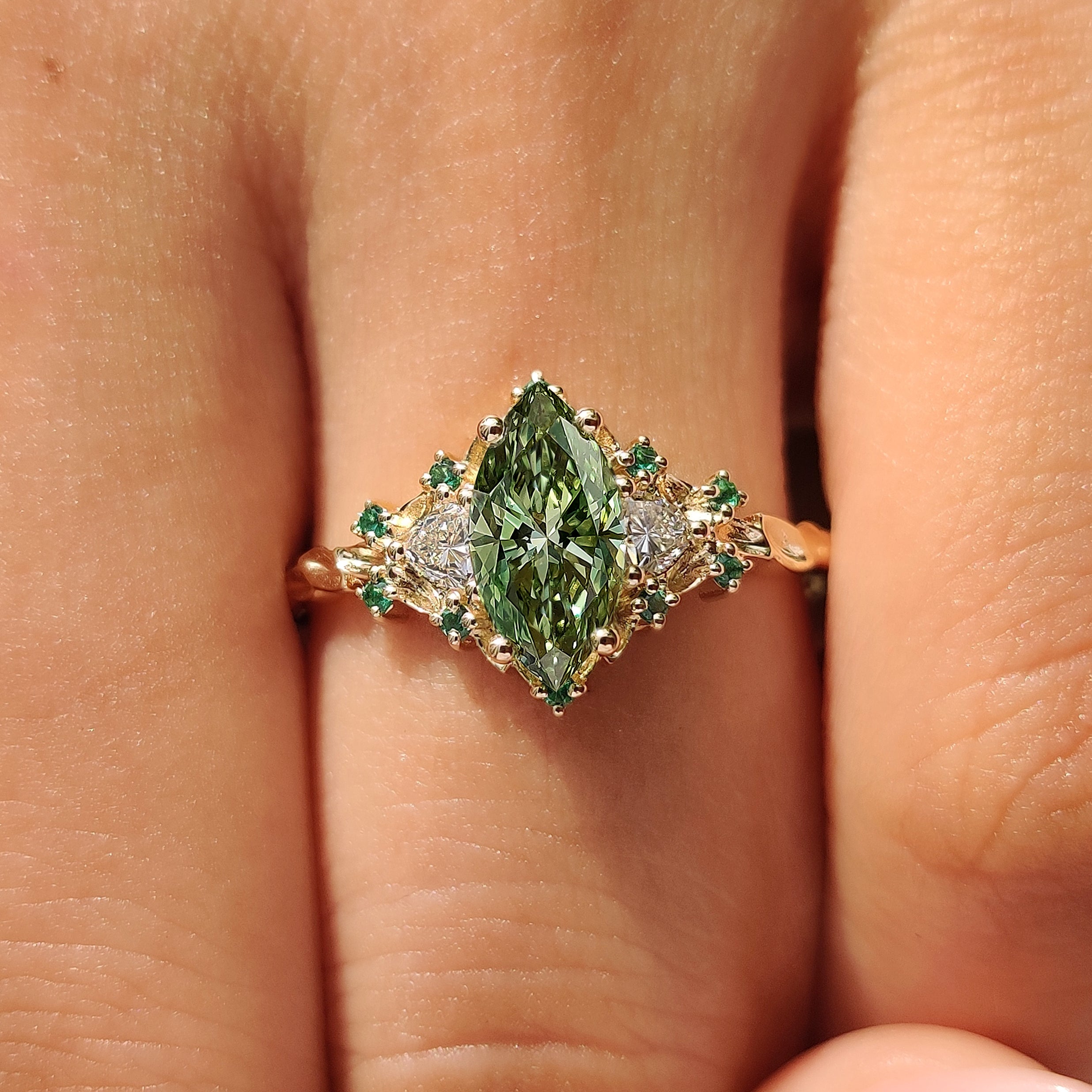 Trillion side stone cluster ring with green emerald accents.
