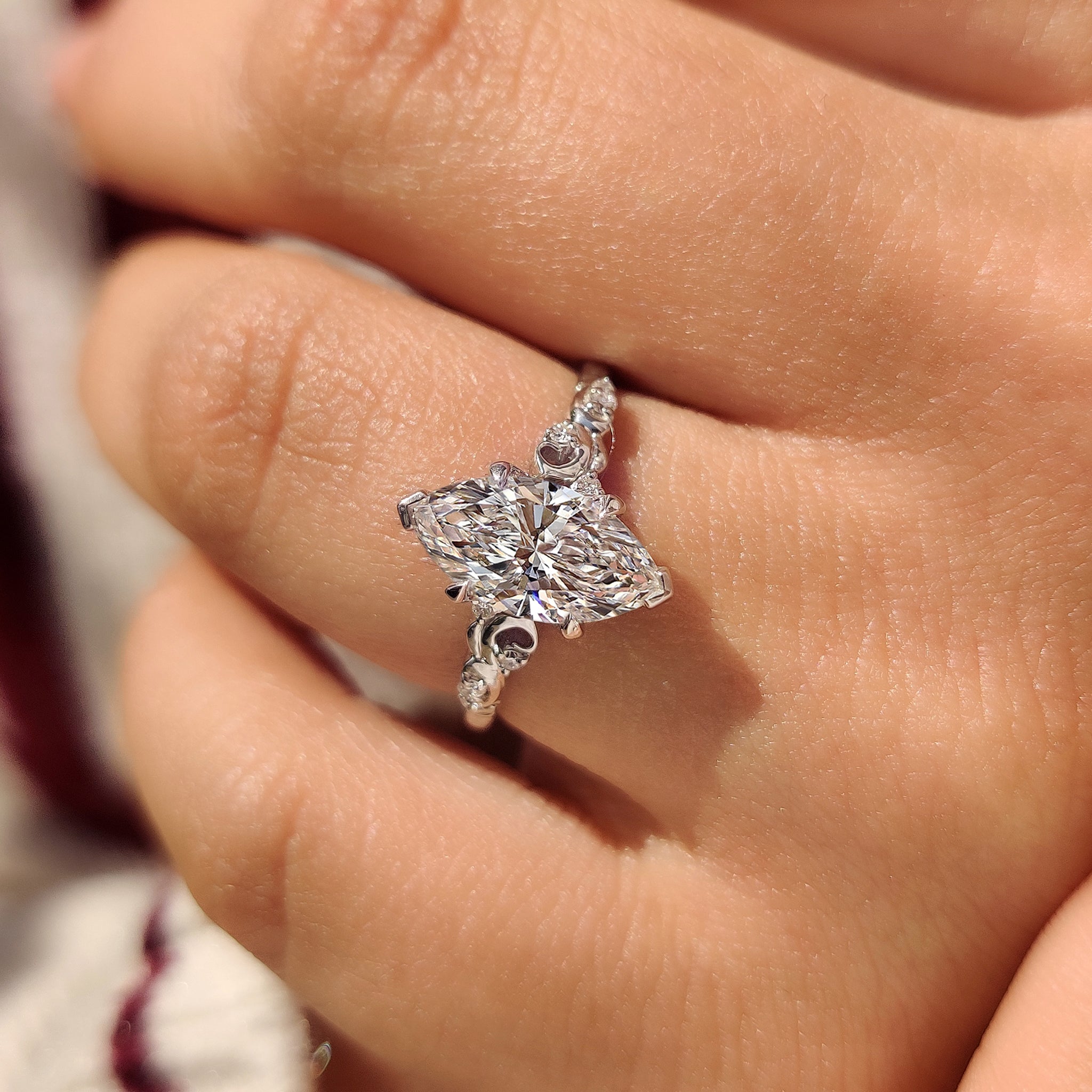 Marquise cut engagement ring with tulip style setting details
