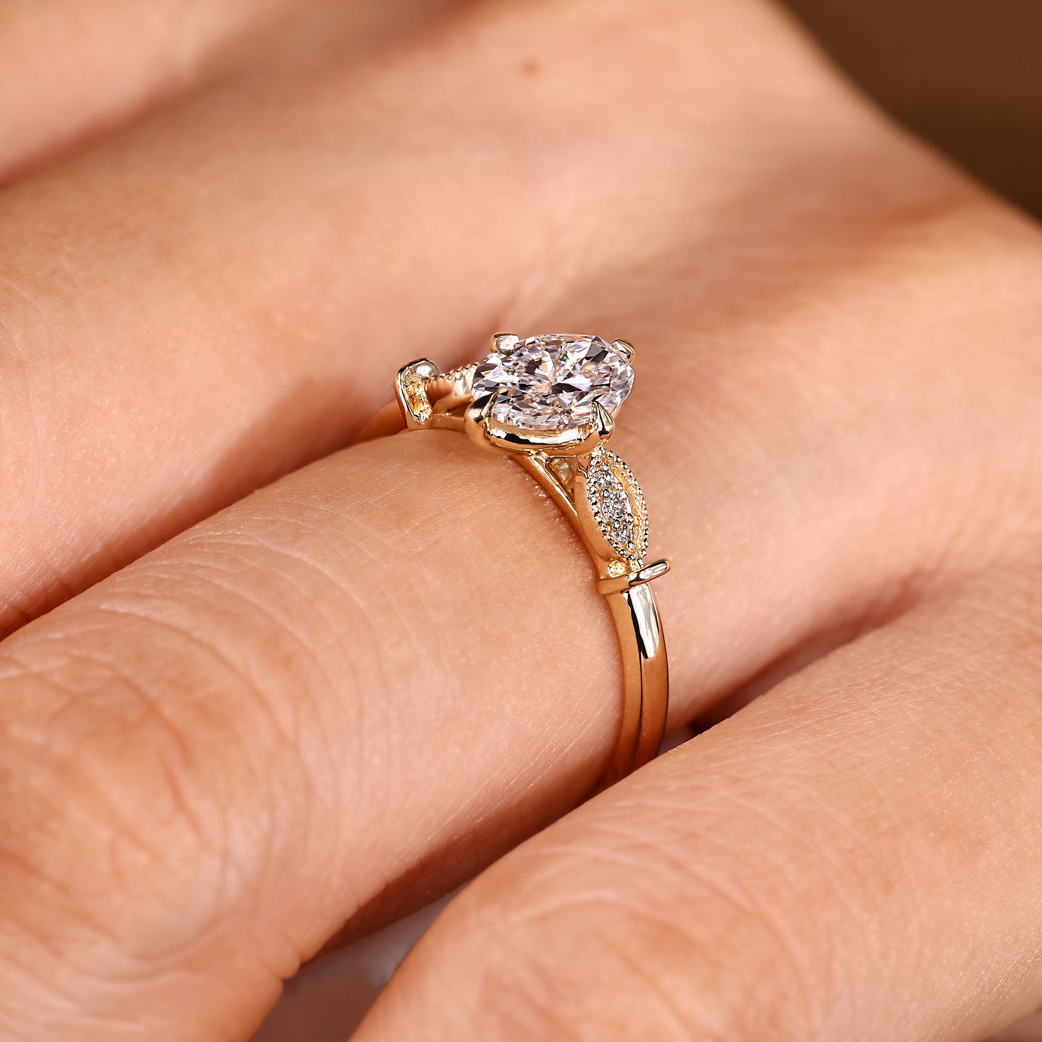 Oval diamond ring with milgrain details and side stones
