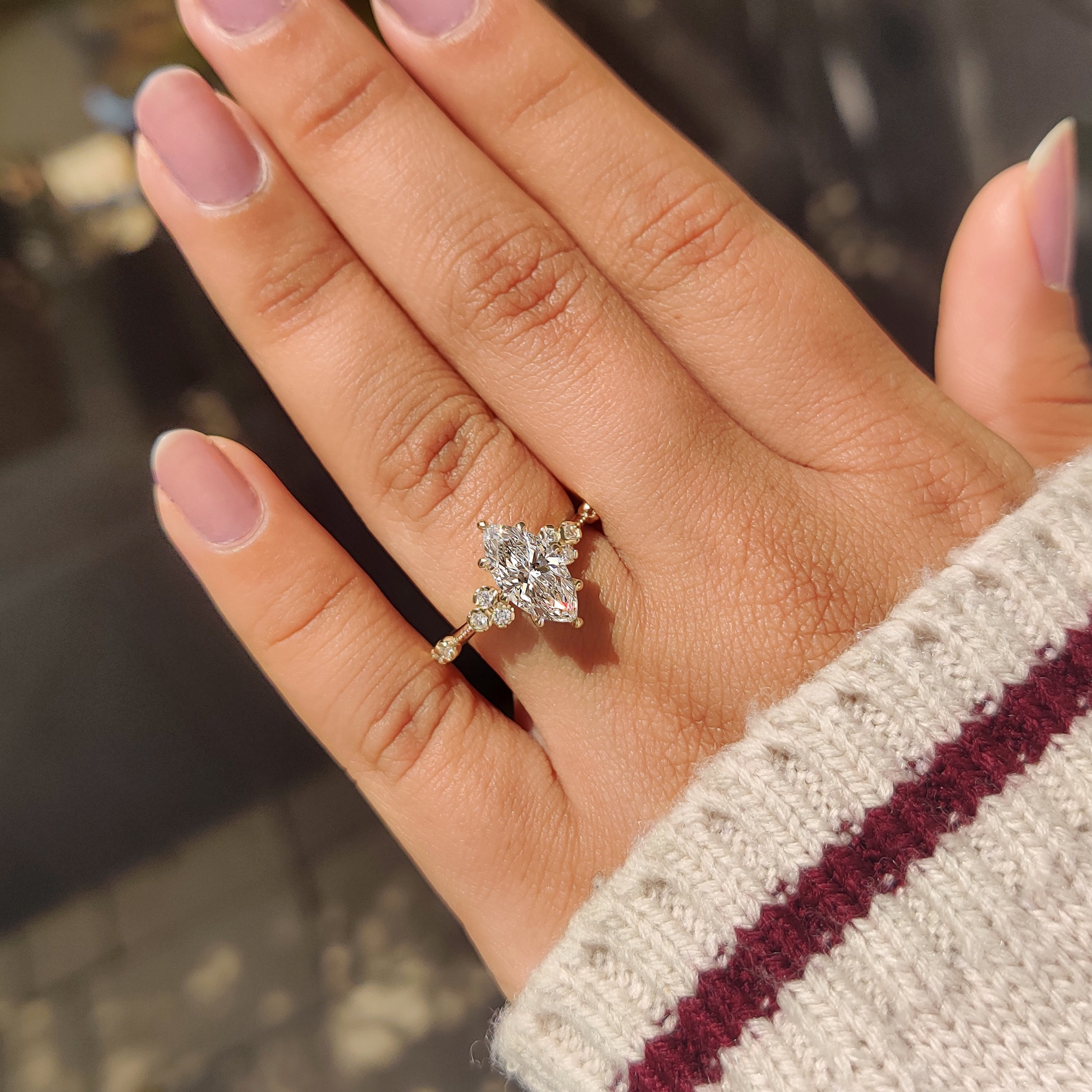Marquise diamond ring with round accents and knife edge band.
