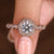 Round cut diamond ring with twisted pave halo design
