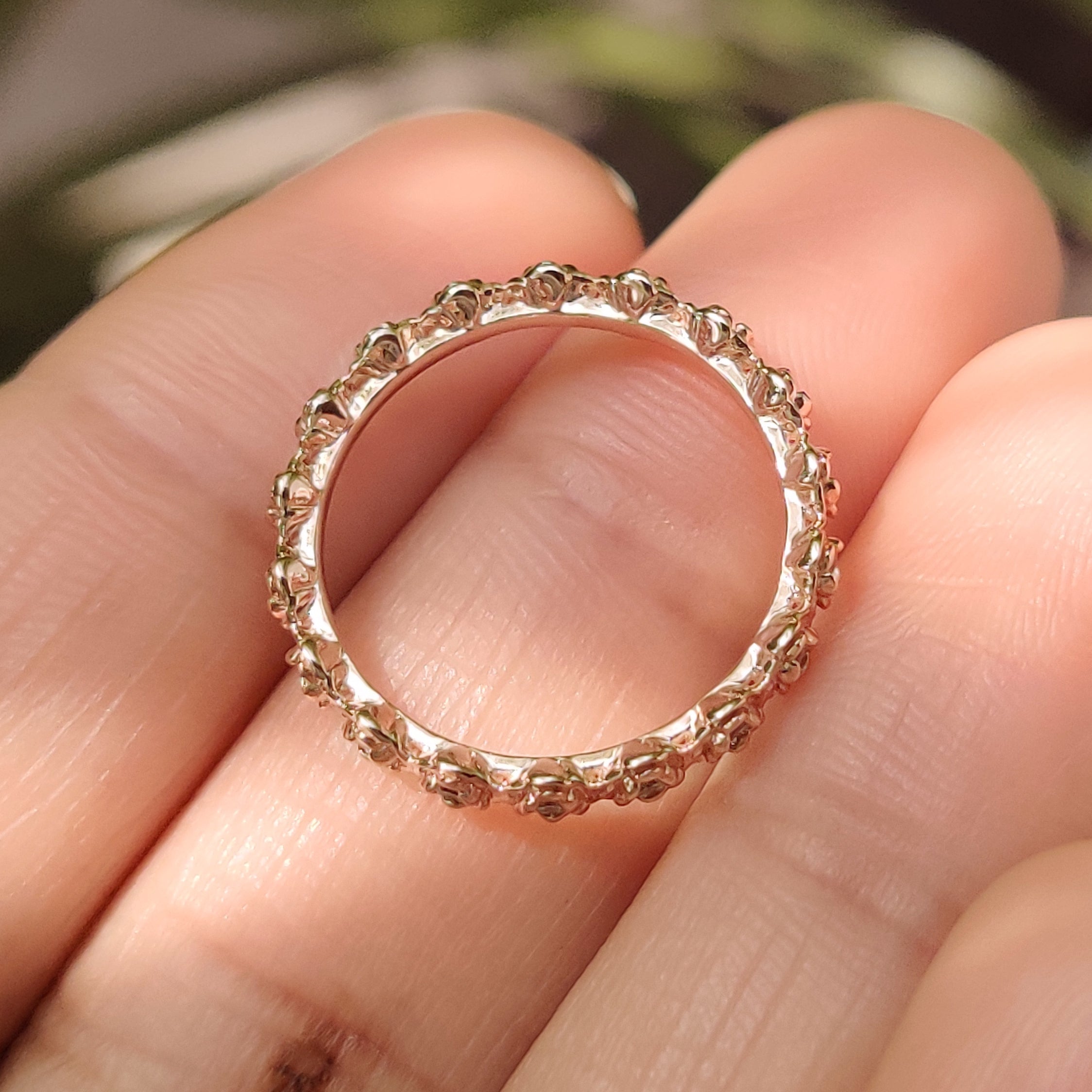Handmade eternity band with round diamond floral elements.
