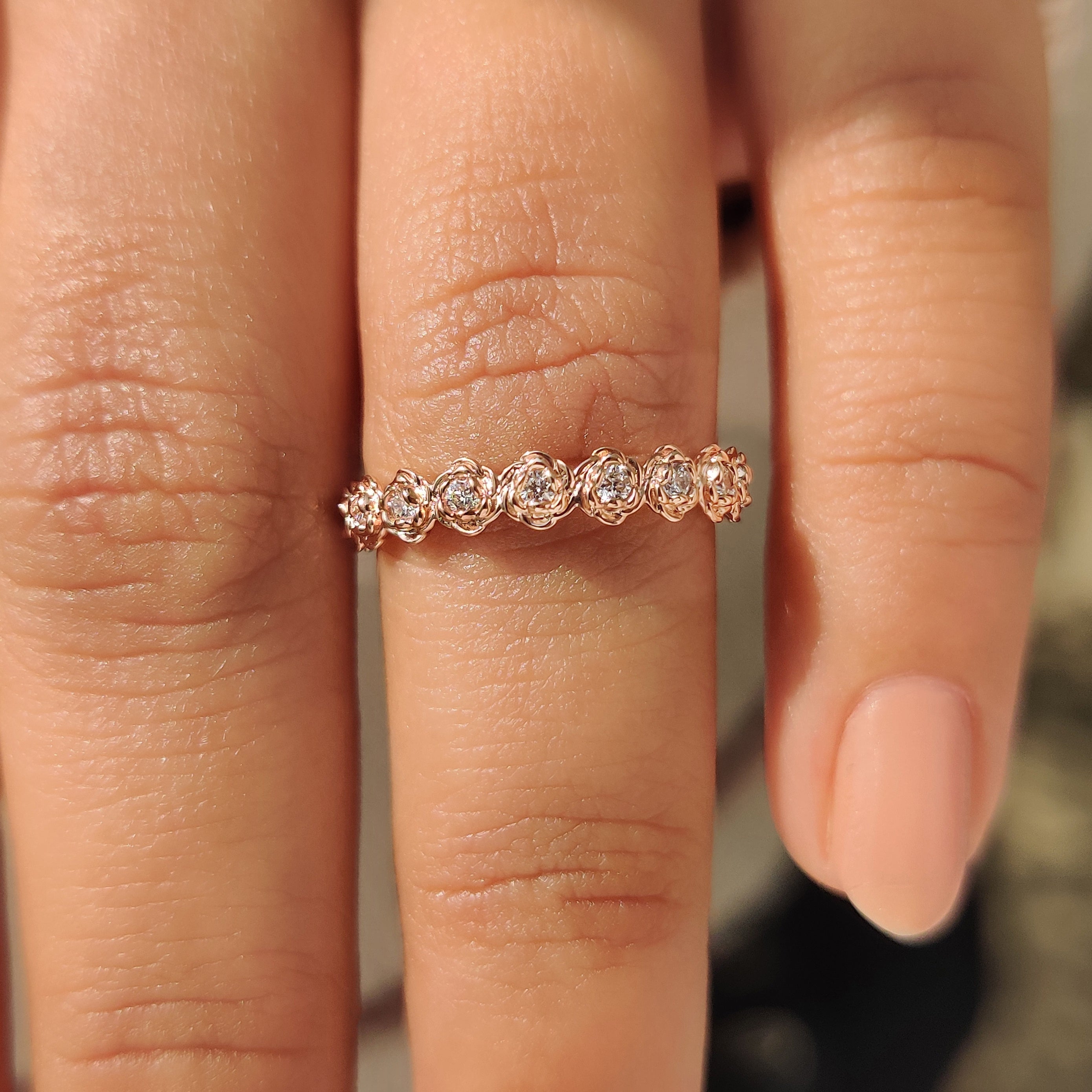 Eternity style wedding band with round diamond floral pattern.
