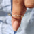 A close-up of a flush set wedding band resting on a velvet ring box.
