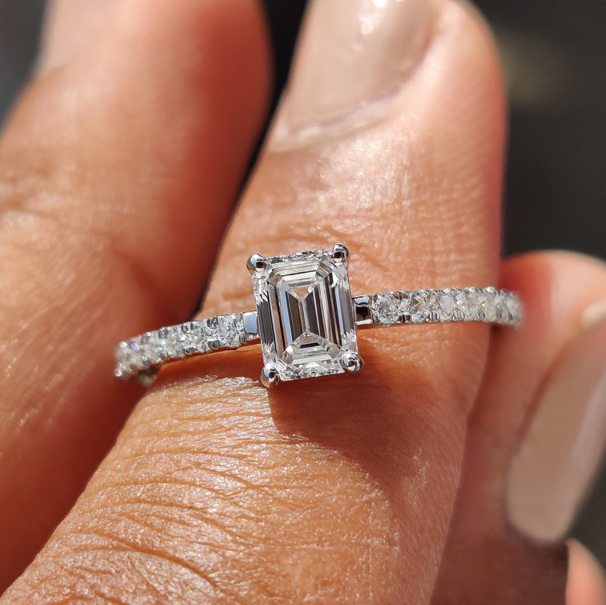 Emerald pave ring featuring a stunning emerald cut diamond.