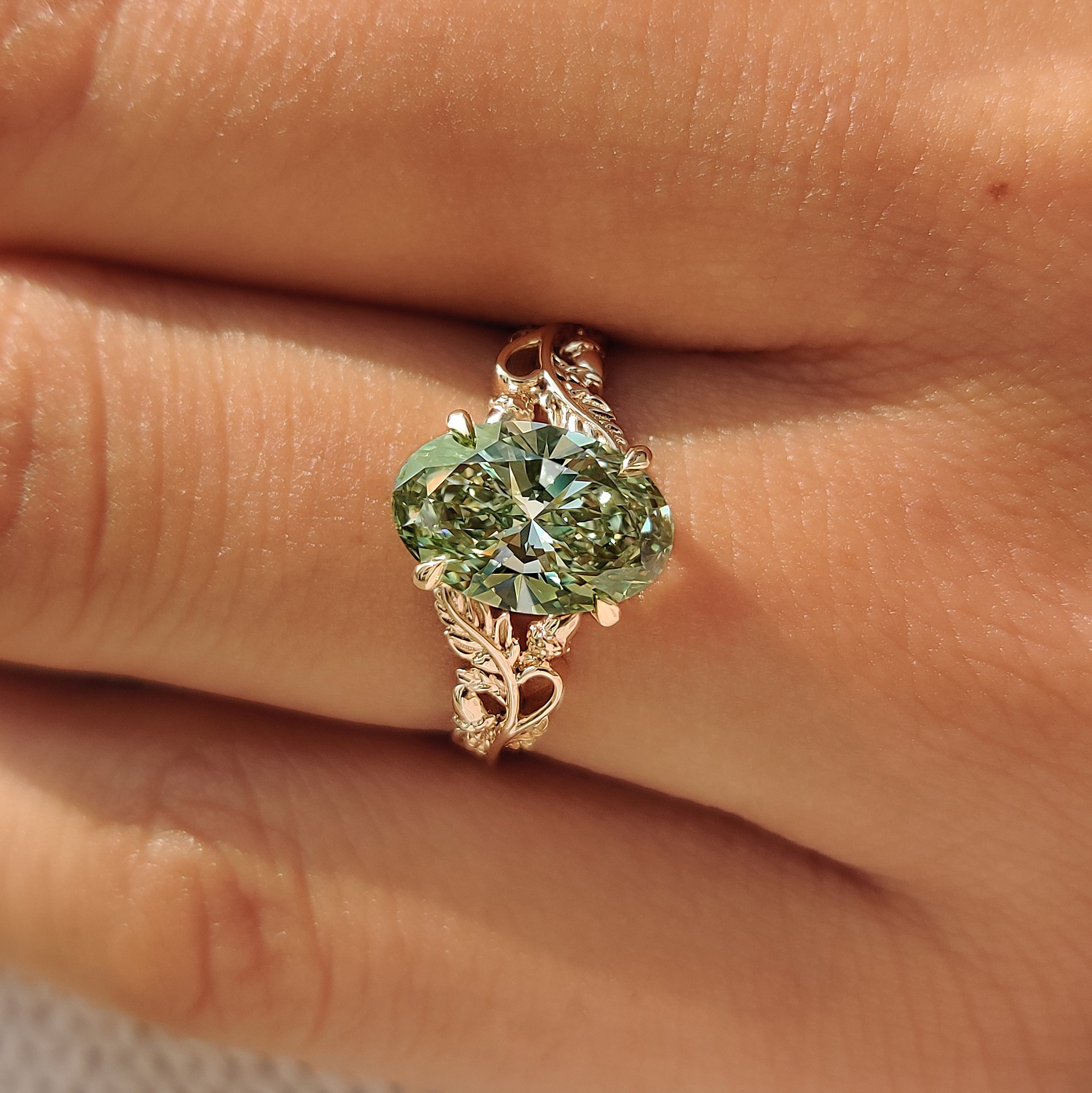 Yellow gold engagement ring with green oval cut lab grown diamond.

