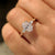 Oval diamond three stone ring with round side accents.
