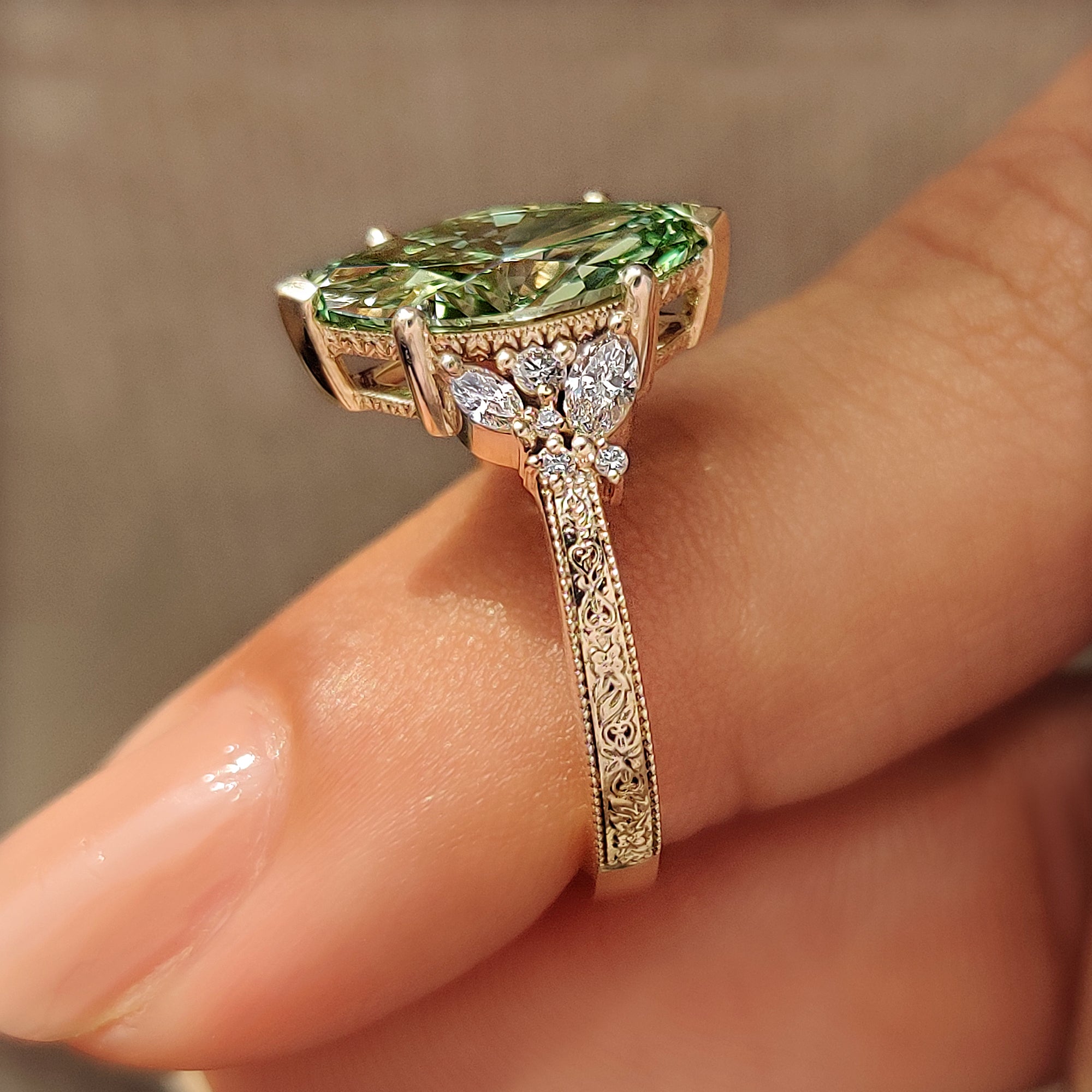 Green diamond ring with round diamond accents.
