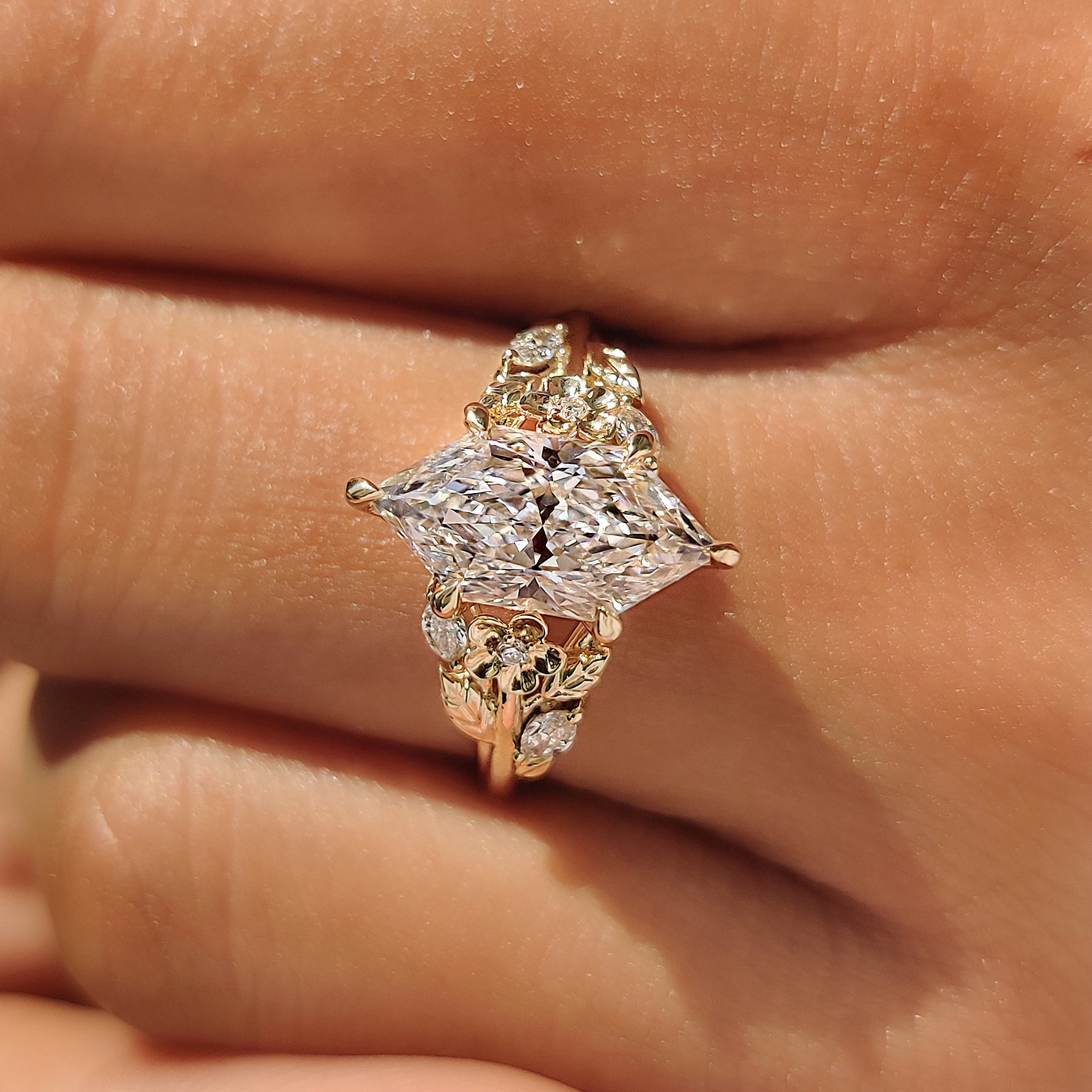 Marquise and round side stones set in leaf and flower design.
