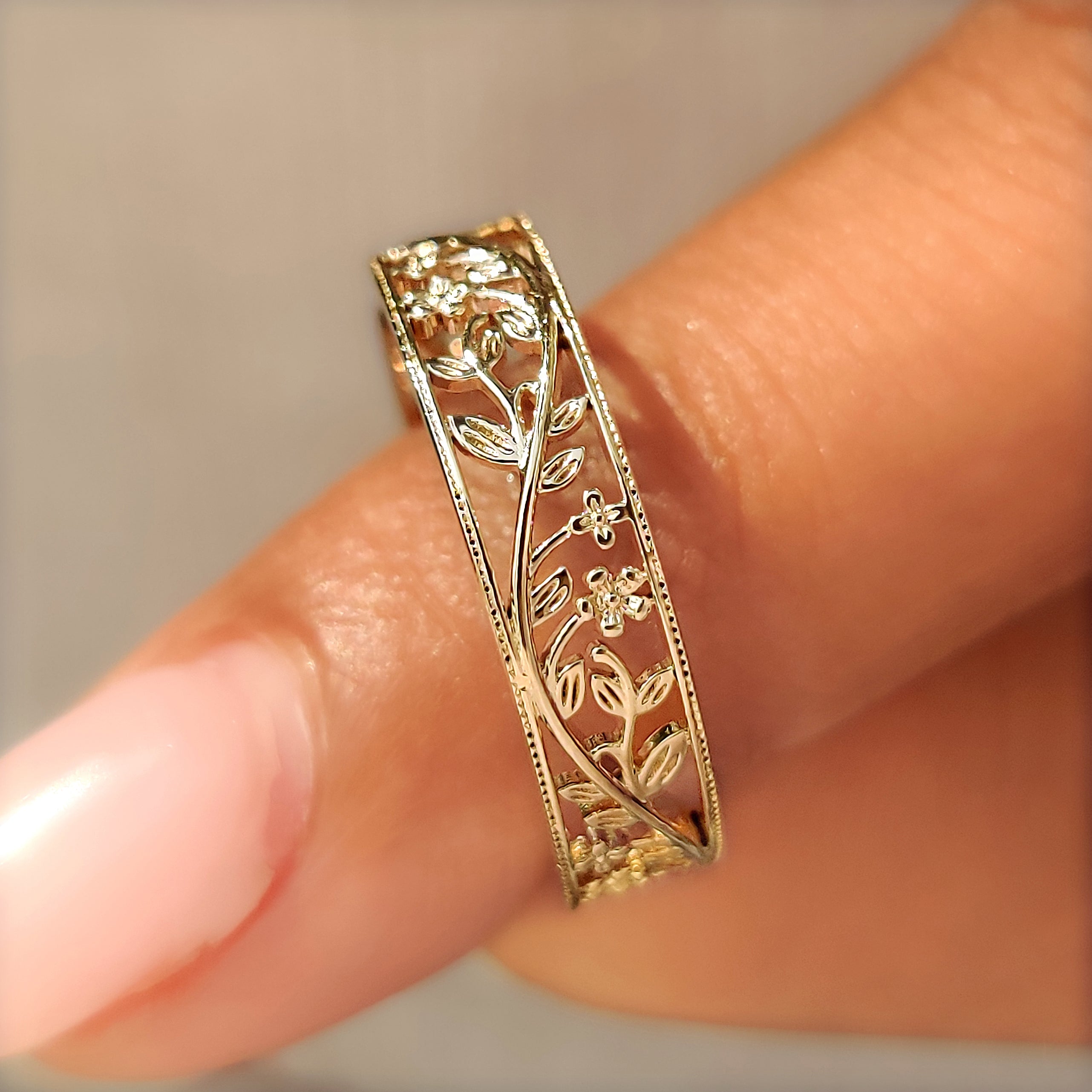 Close up of cherry blossom inspired details on a wedding band.
