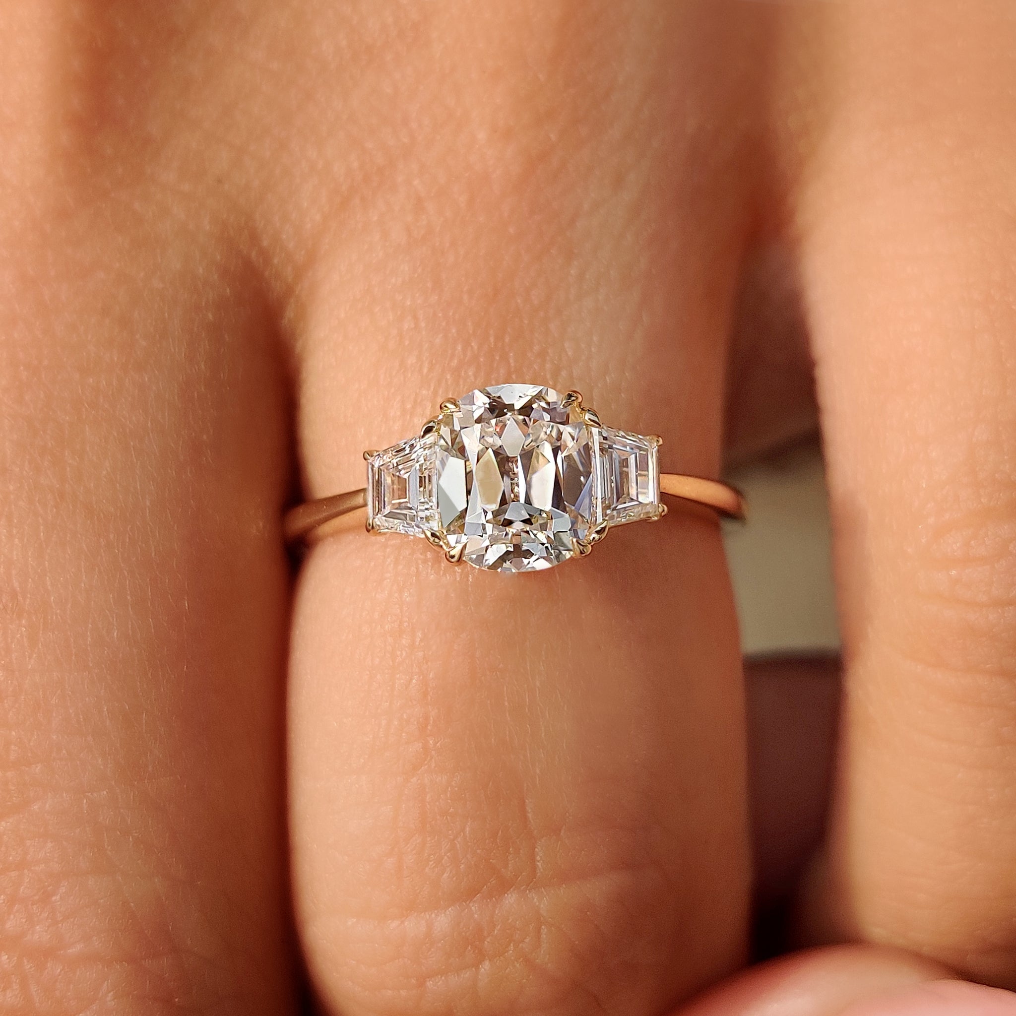 Cushion cut diamond ring featuring three stone design
