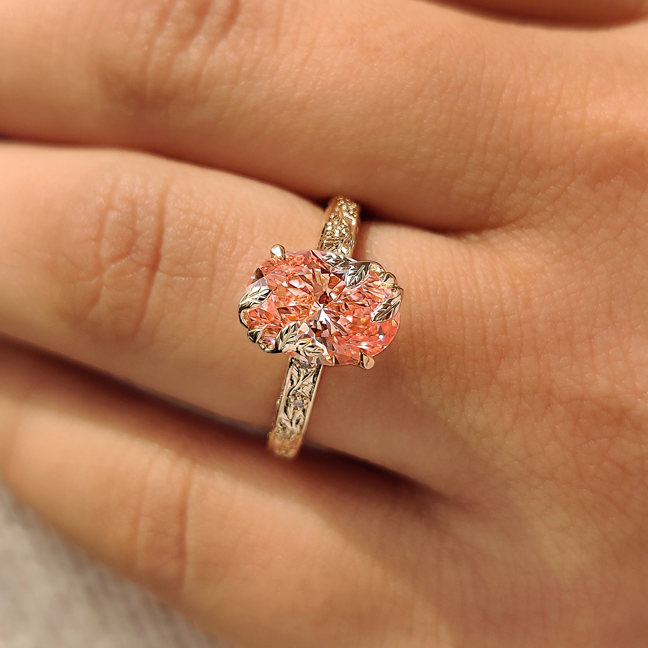 Round diamond accent ring with pink oval center diamond.
