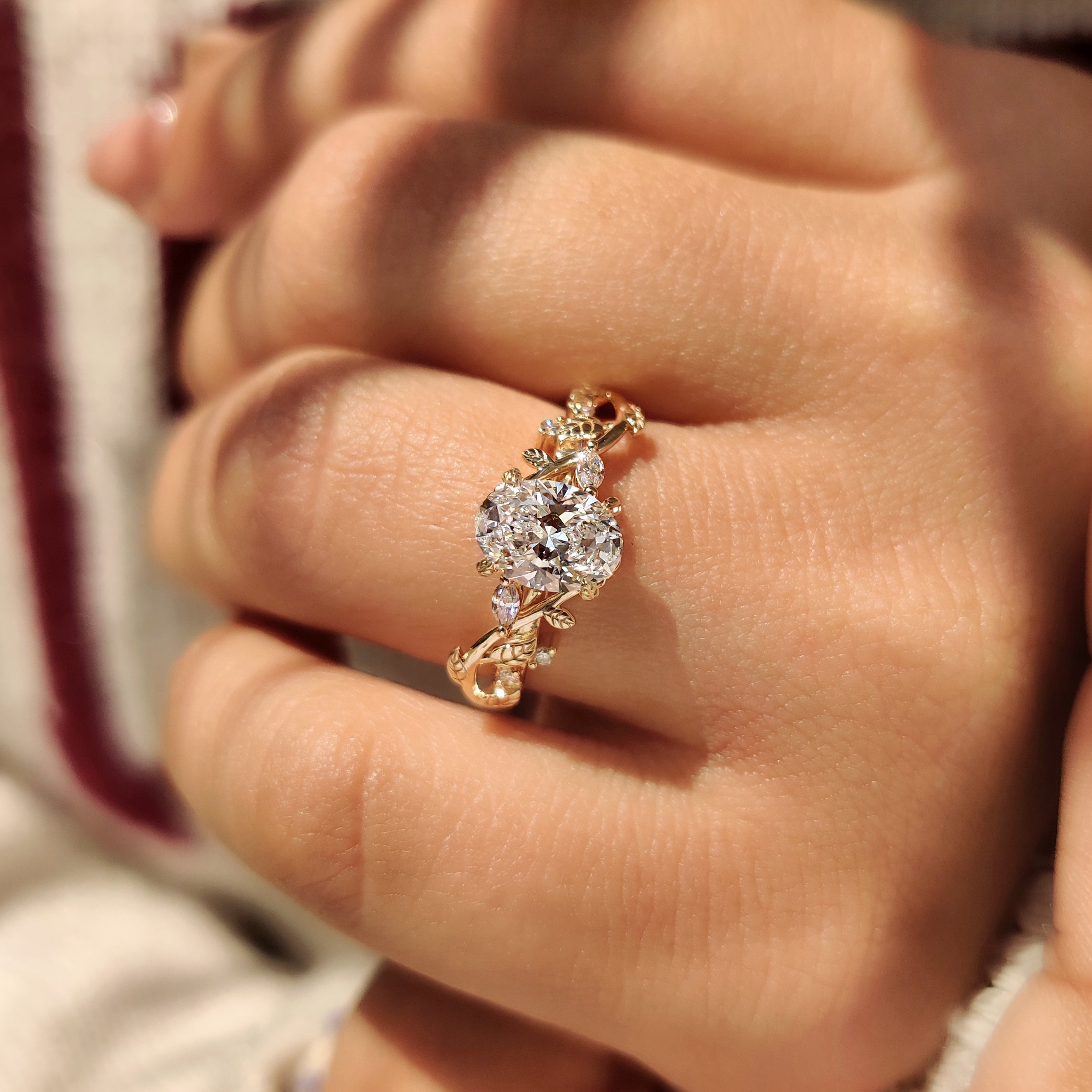 Handmade oval diamond ring with leaf pattern side stones.
