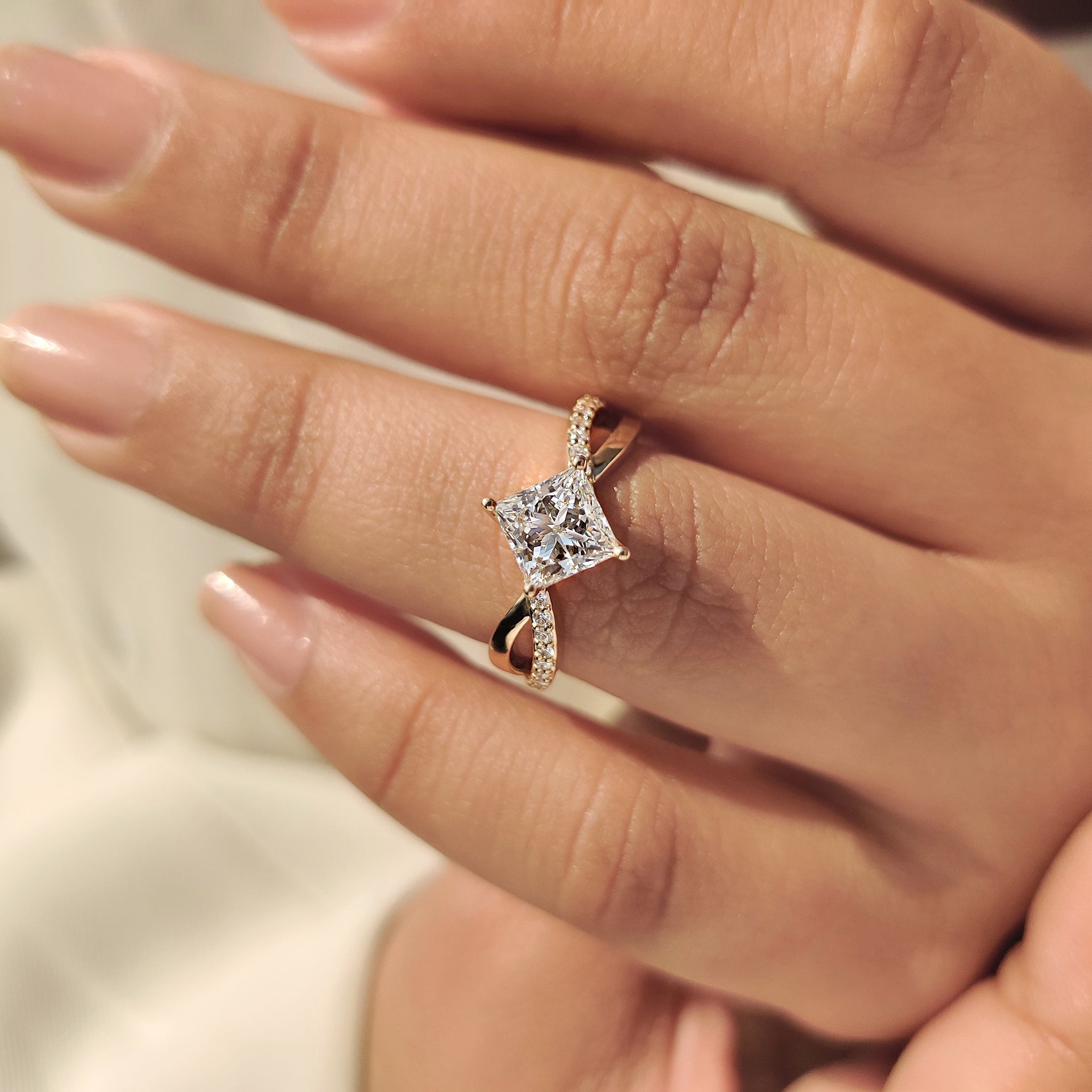 Princess cut diamond ring featuring twisted pave band

