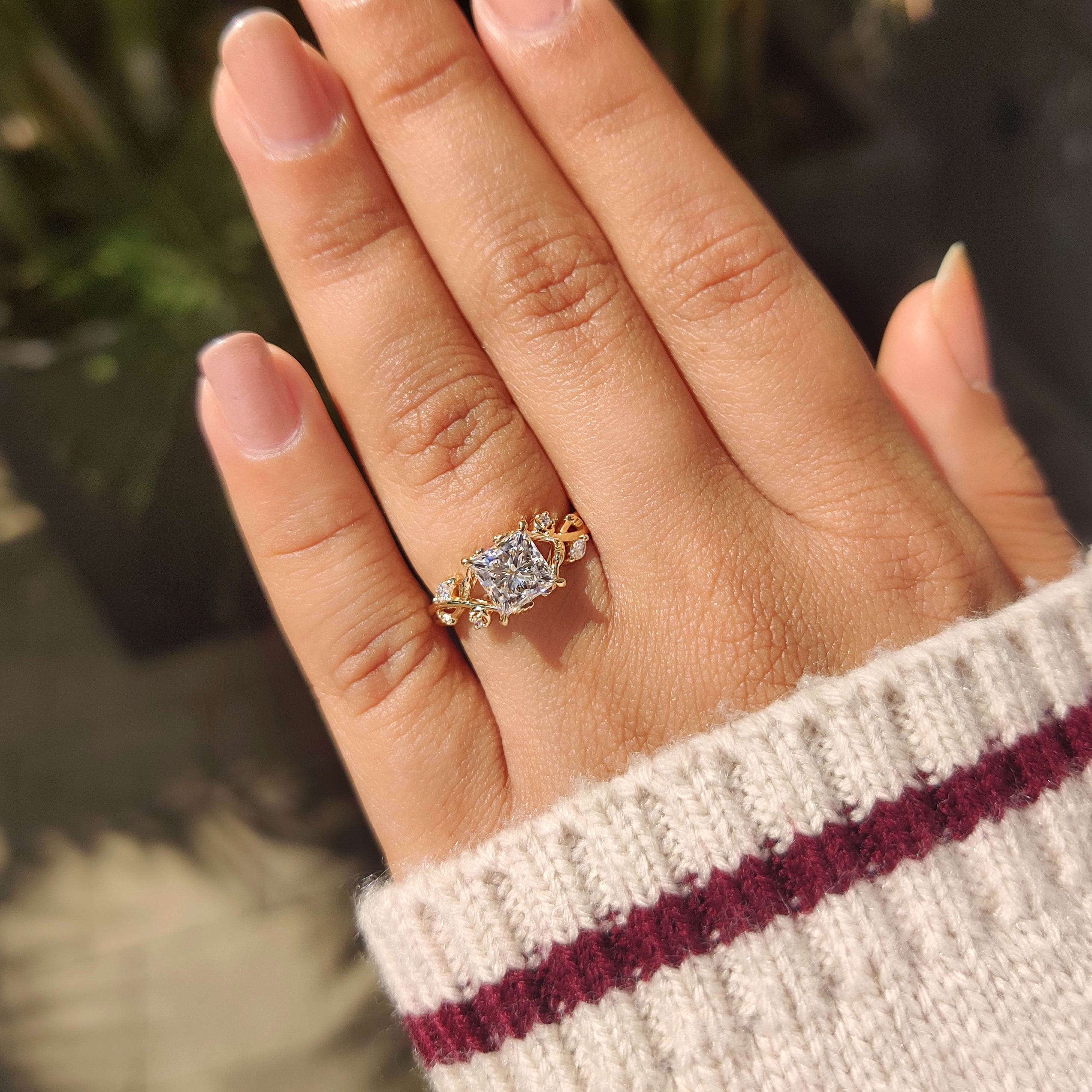 Princess diamond ring with petal design and side stones.

