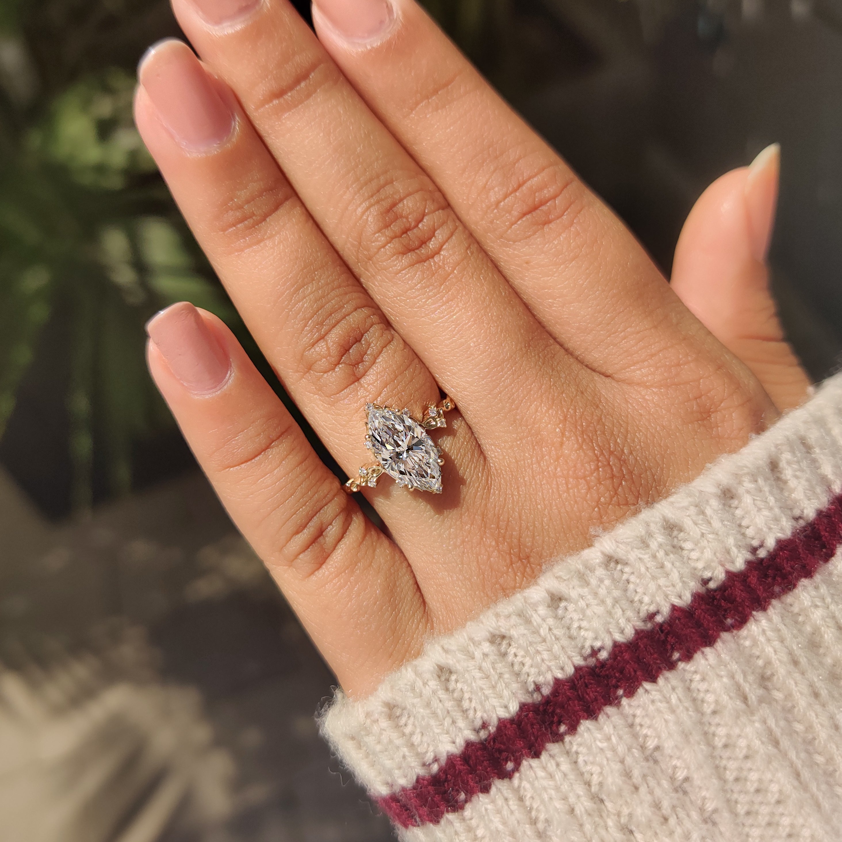 Marquise cut diamond ring with cluster and round stones.
