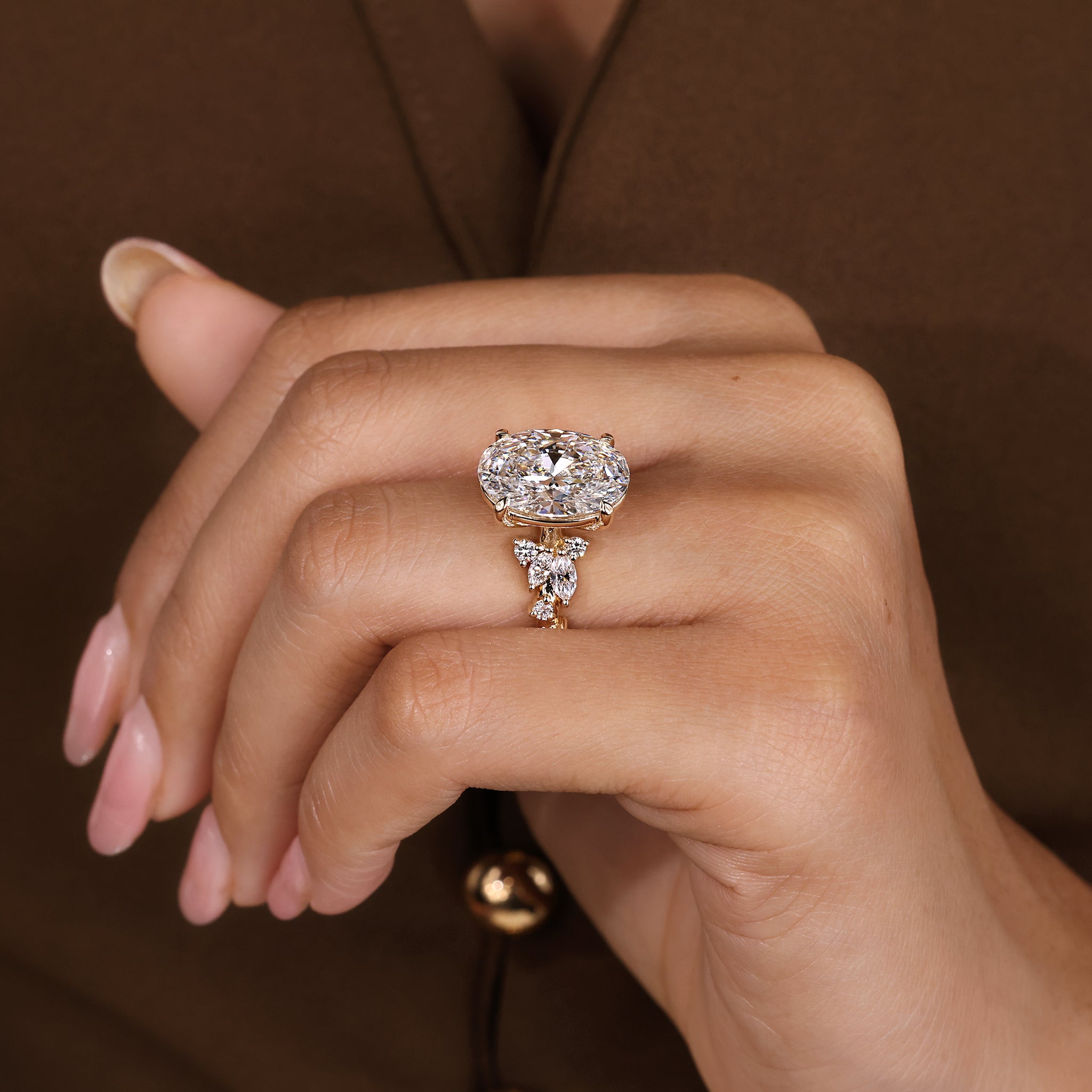 Oval cut lab grown diamond ring with sparkling cluster of marquise and round stones.
