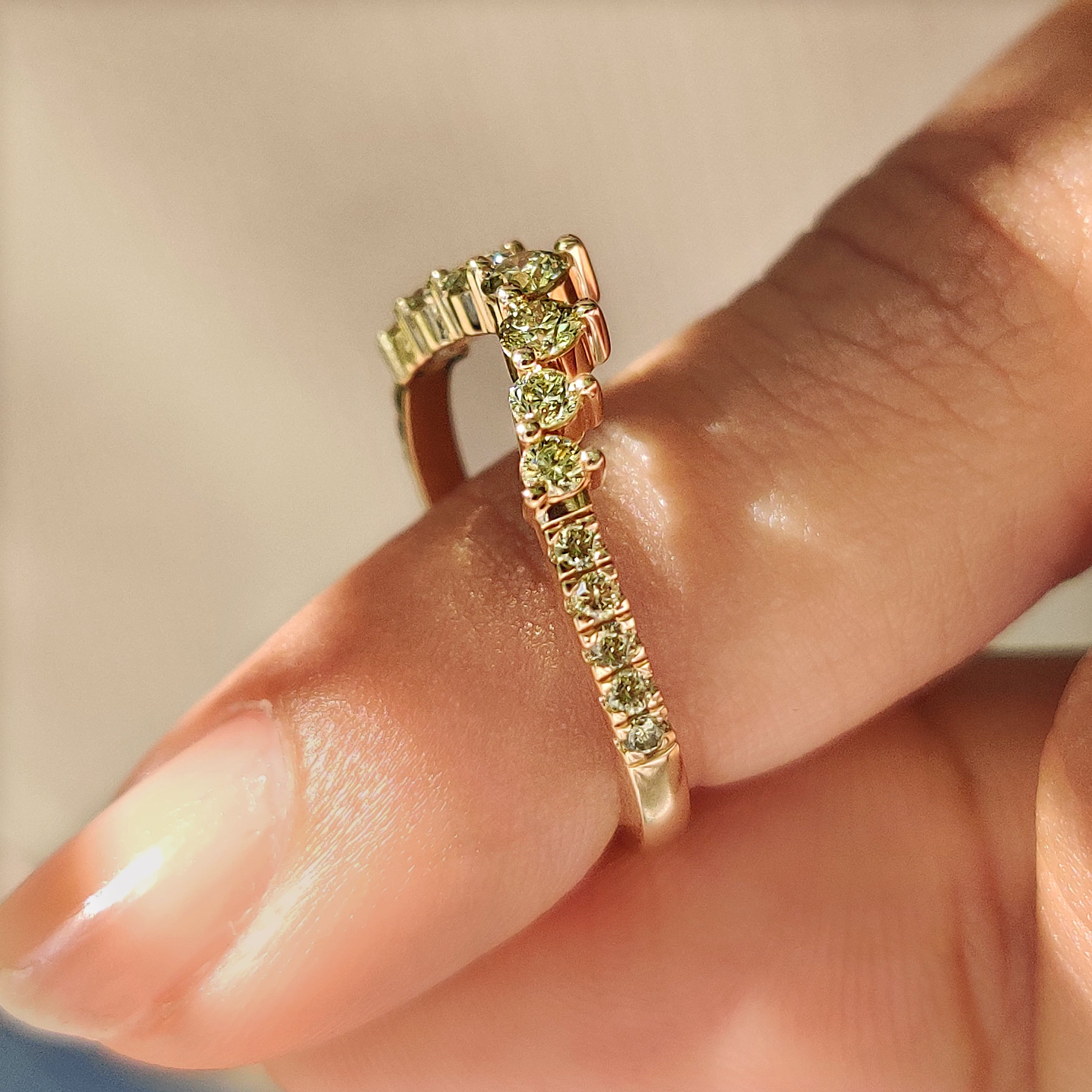 V shape wedding band with green diamonds and prongs
