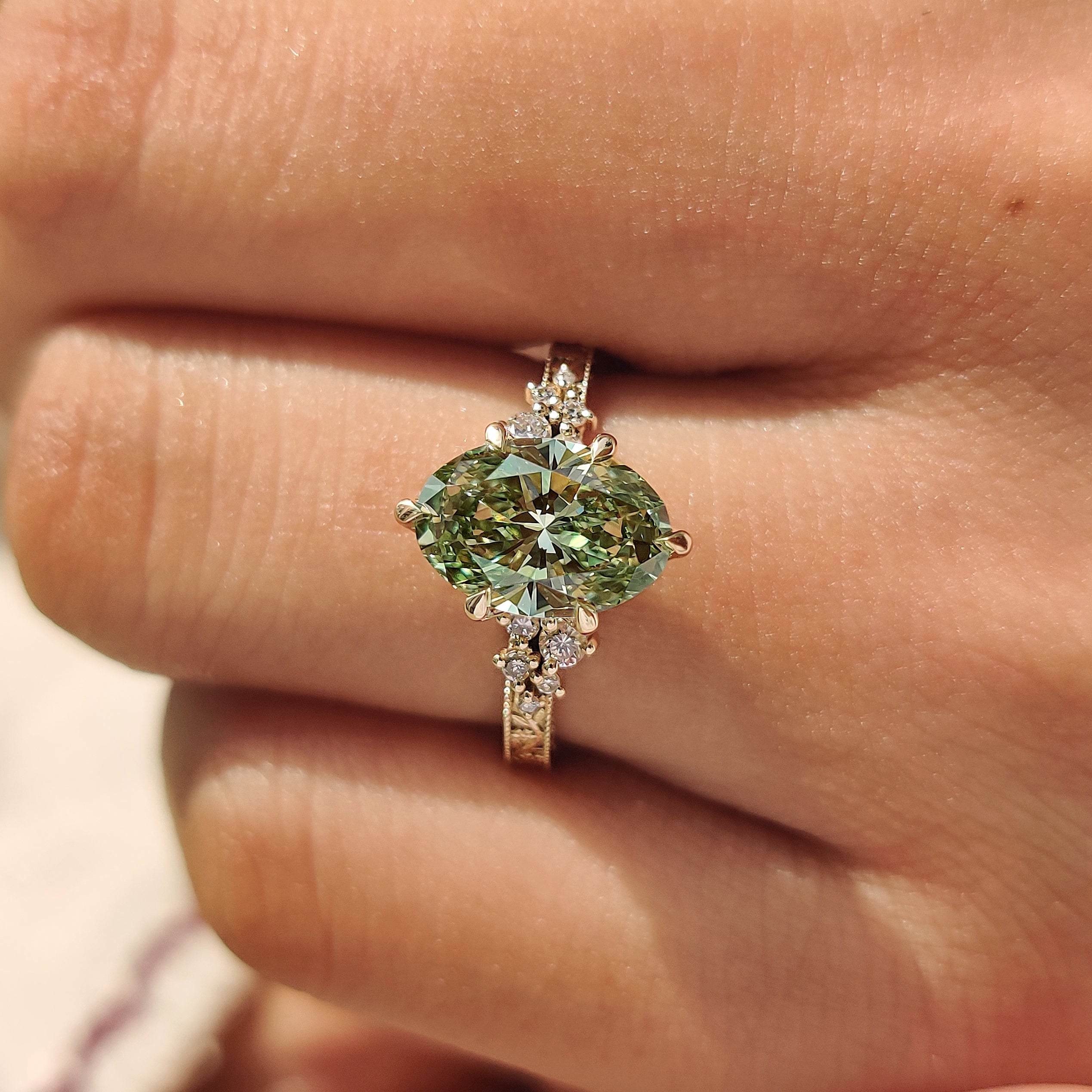 Green oval engagement ring in tulip setting

