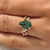 Green pear shaped diamond with leaves and petals design.
