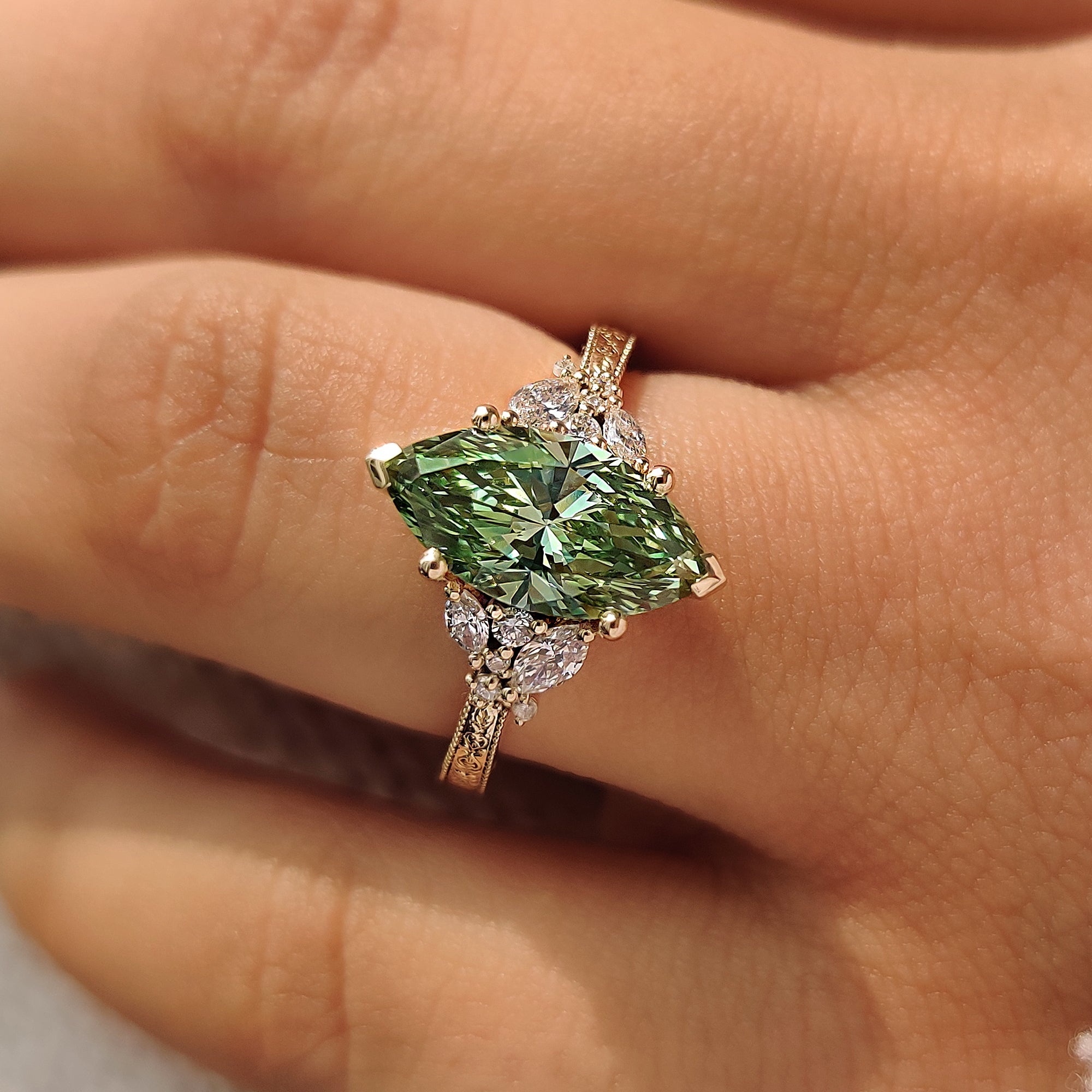 Cluster ring with green marquise center diamond.
