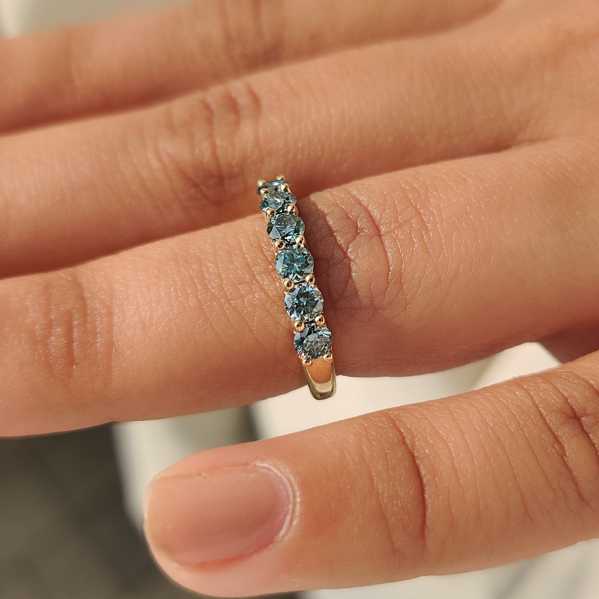 Blue round moissanite band with u prong setting.
