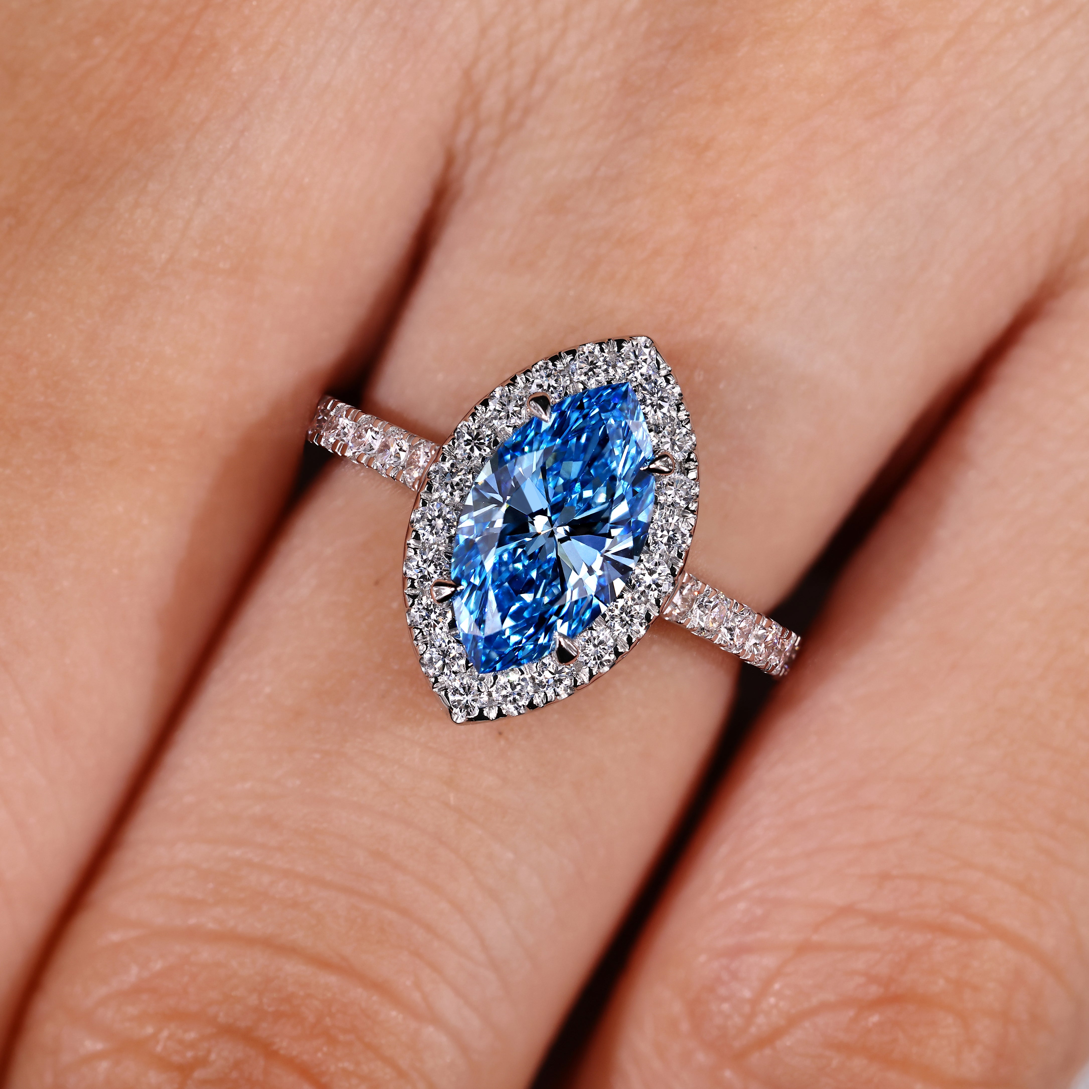 Blue center marquise diamond ring with round halo stones
