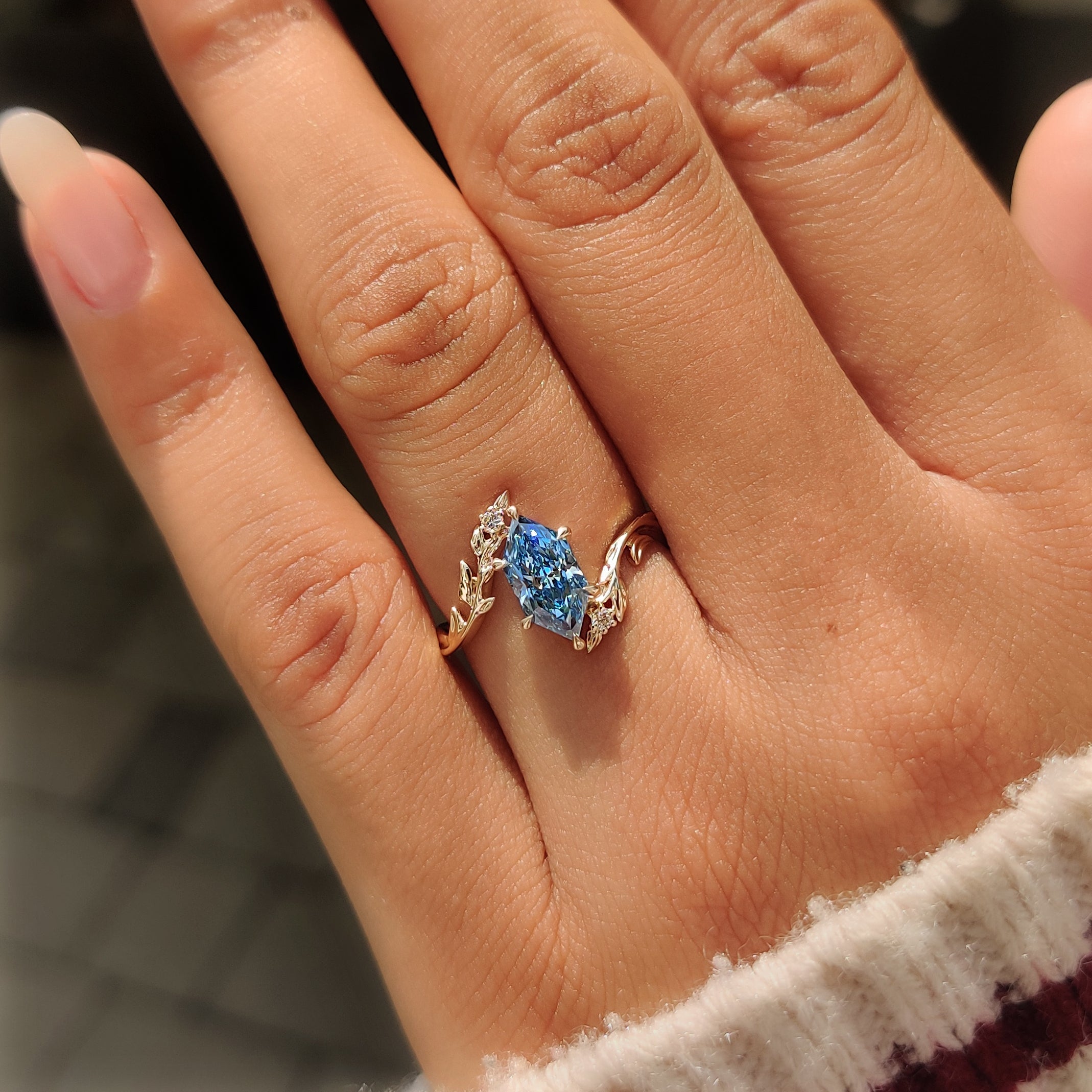 Open gallery basket below a blue Dutch marquise diamond.
