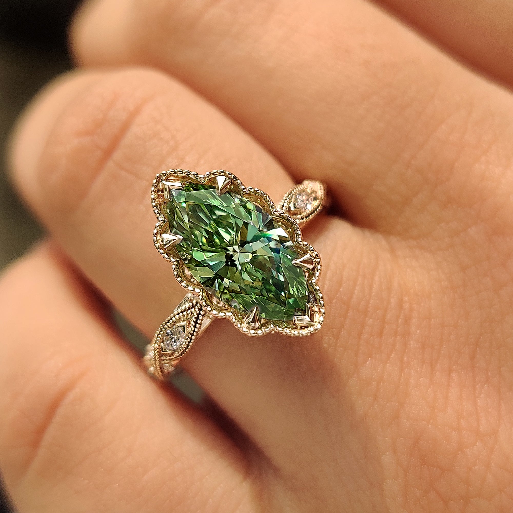 Handcrafted green marquise diamond ring with filigree and milgrain details.
