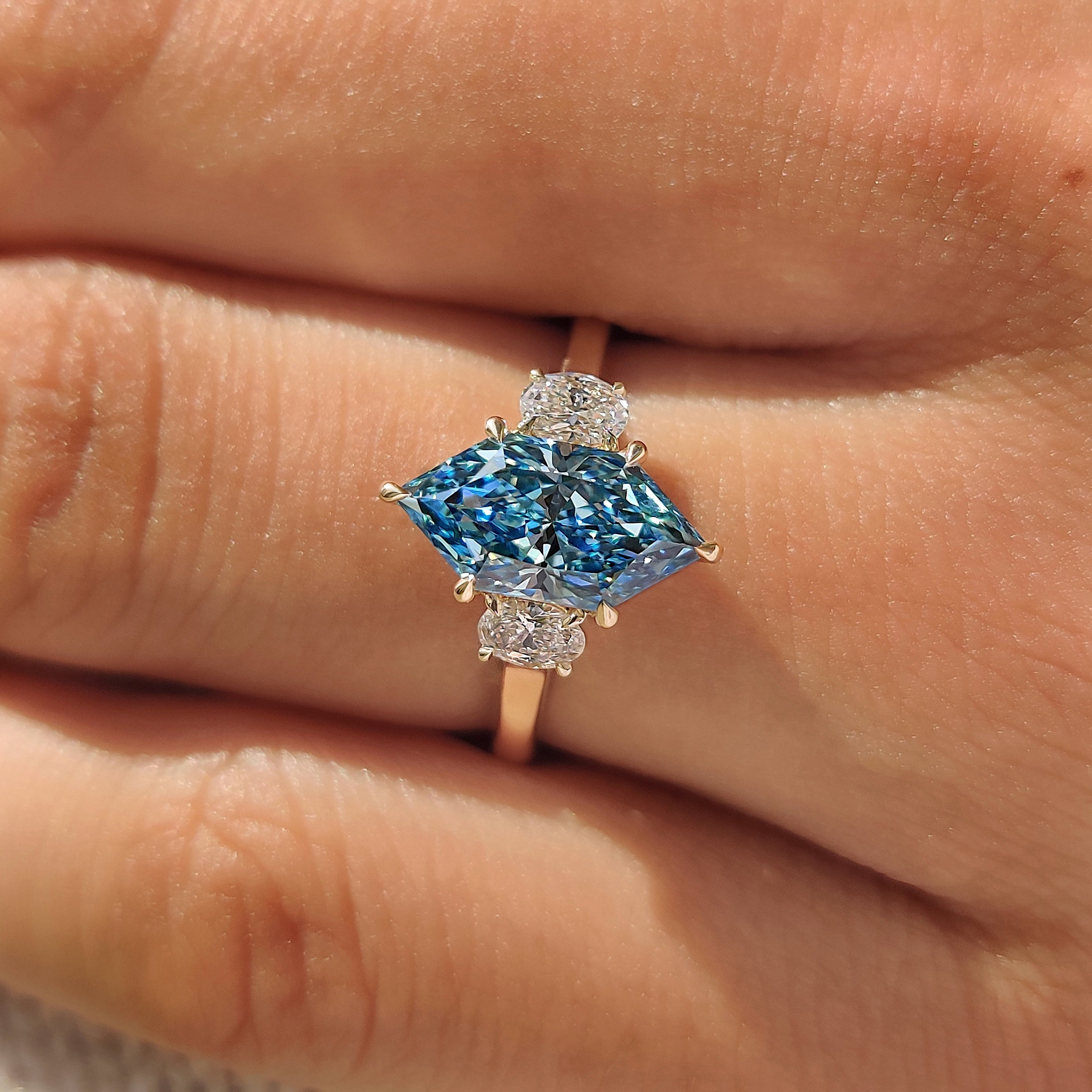 Oval side stones with blue Dutch marquise center diamond.
