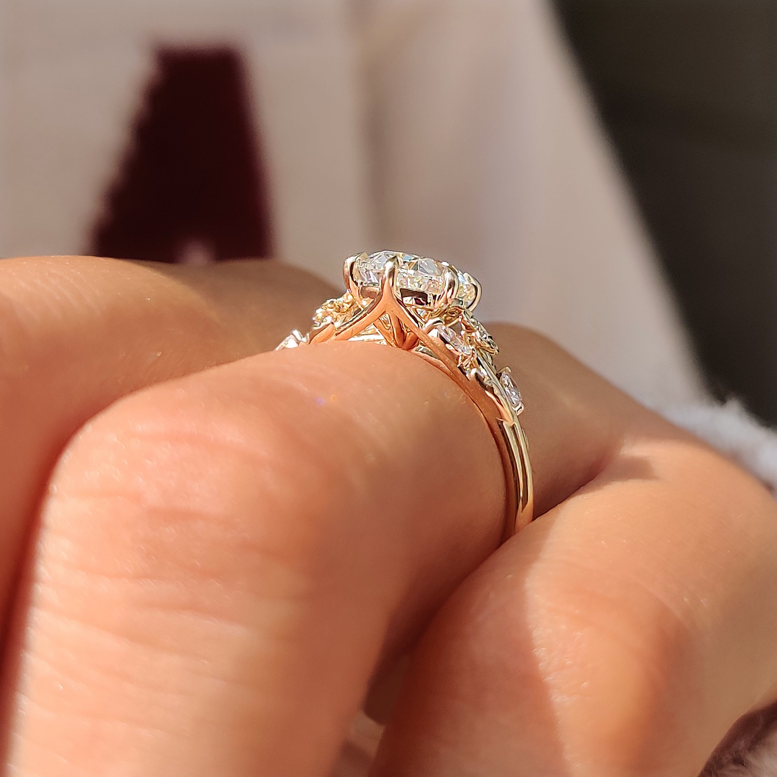 Nature inspired ring with oval center diamond and floral details.
