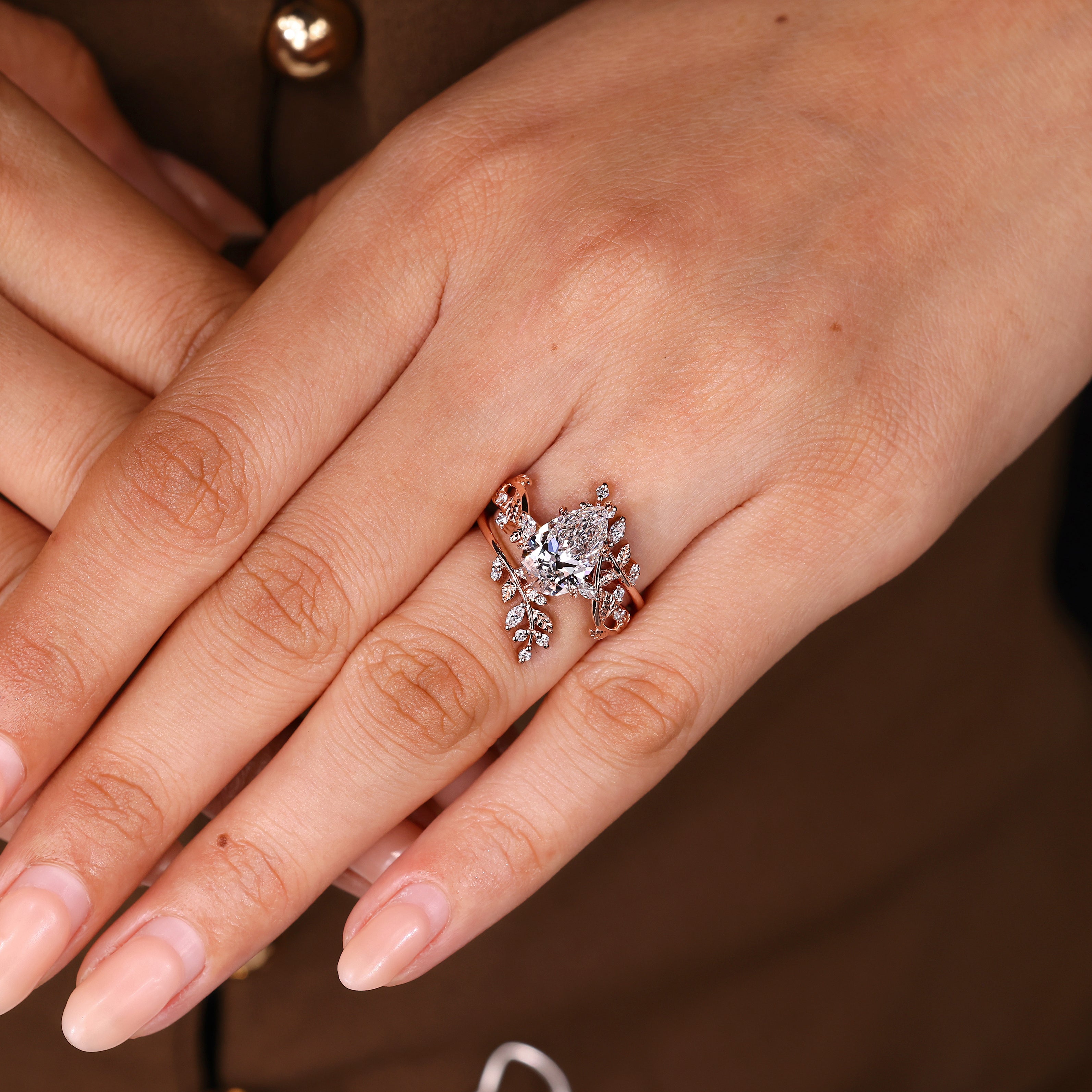 Pear engagement ring with round diamonds and wrap band

