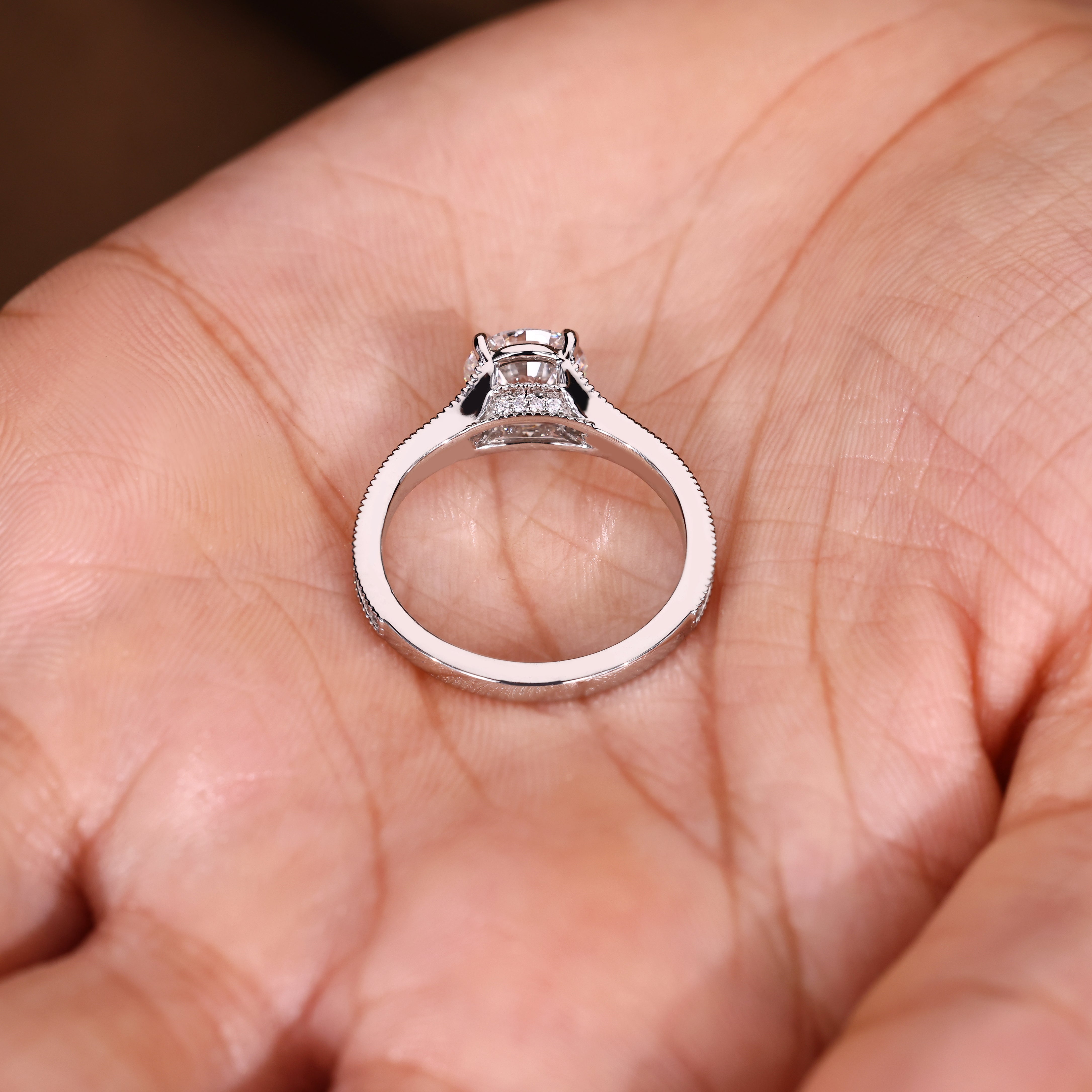 Round diamond ring with milgrain detailing and pave setting
