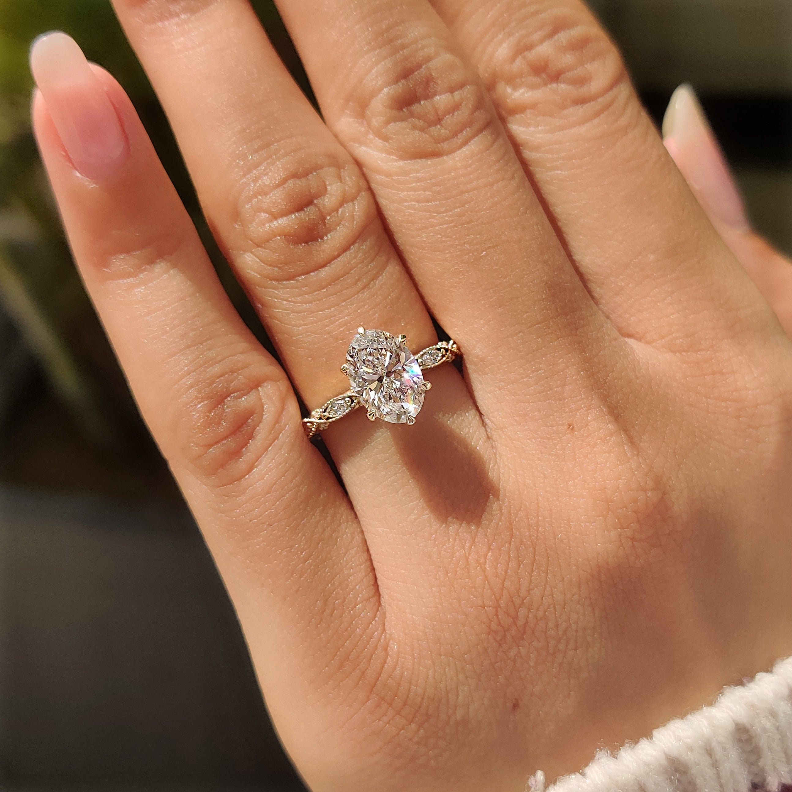 Oval diamond ring with six claw prongs and milgrain accents
