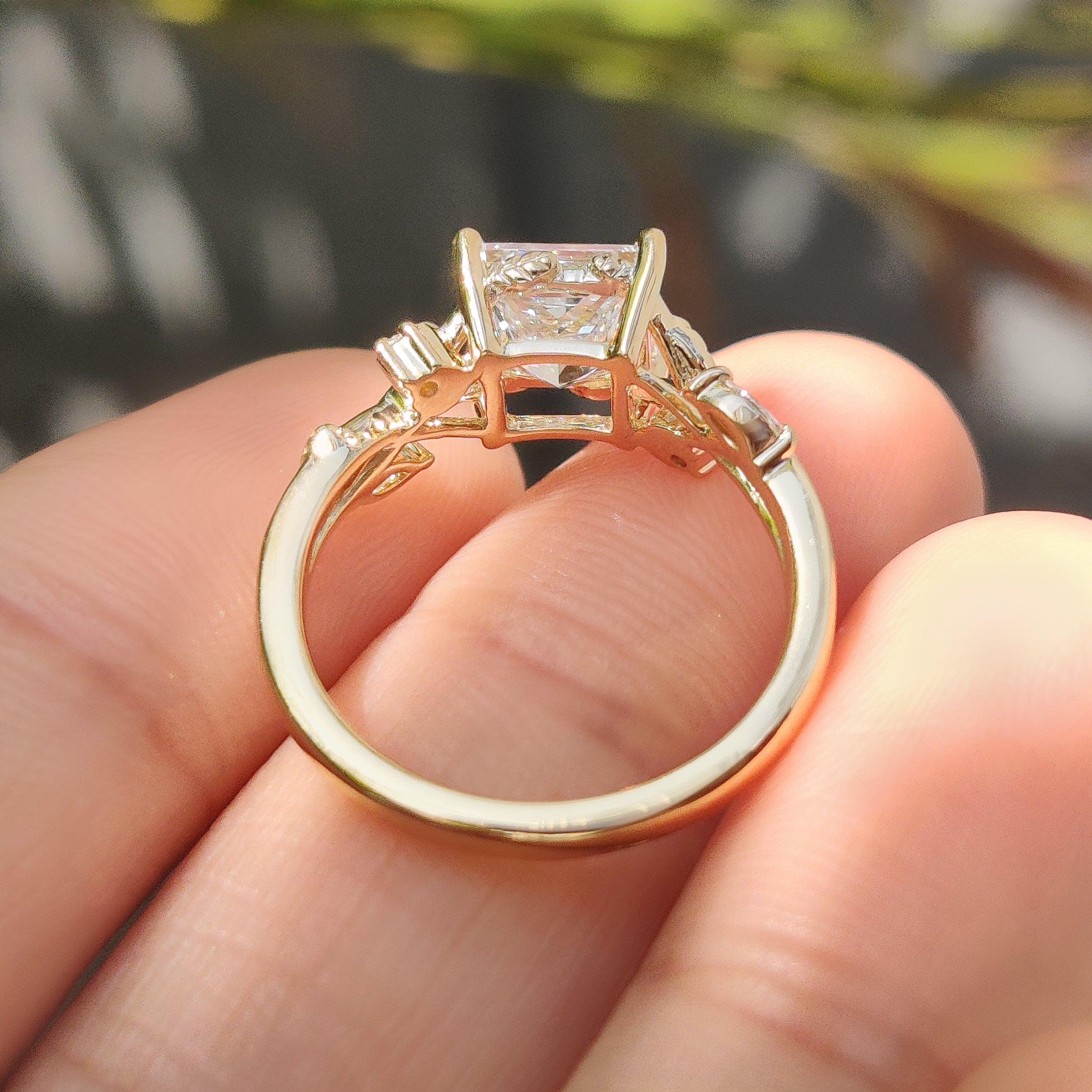 Princess cut ring with leaf details and claw setting.
