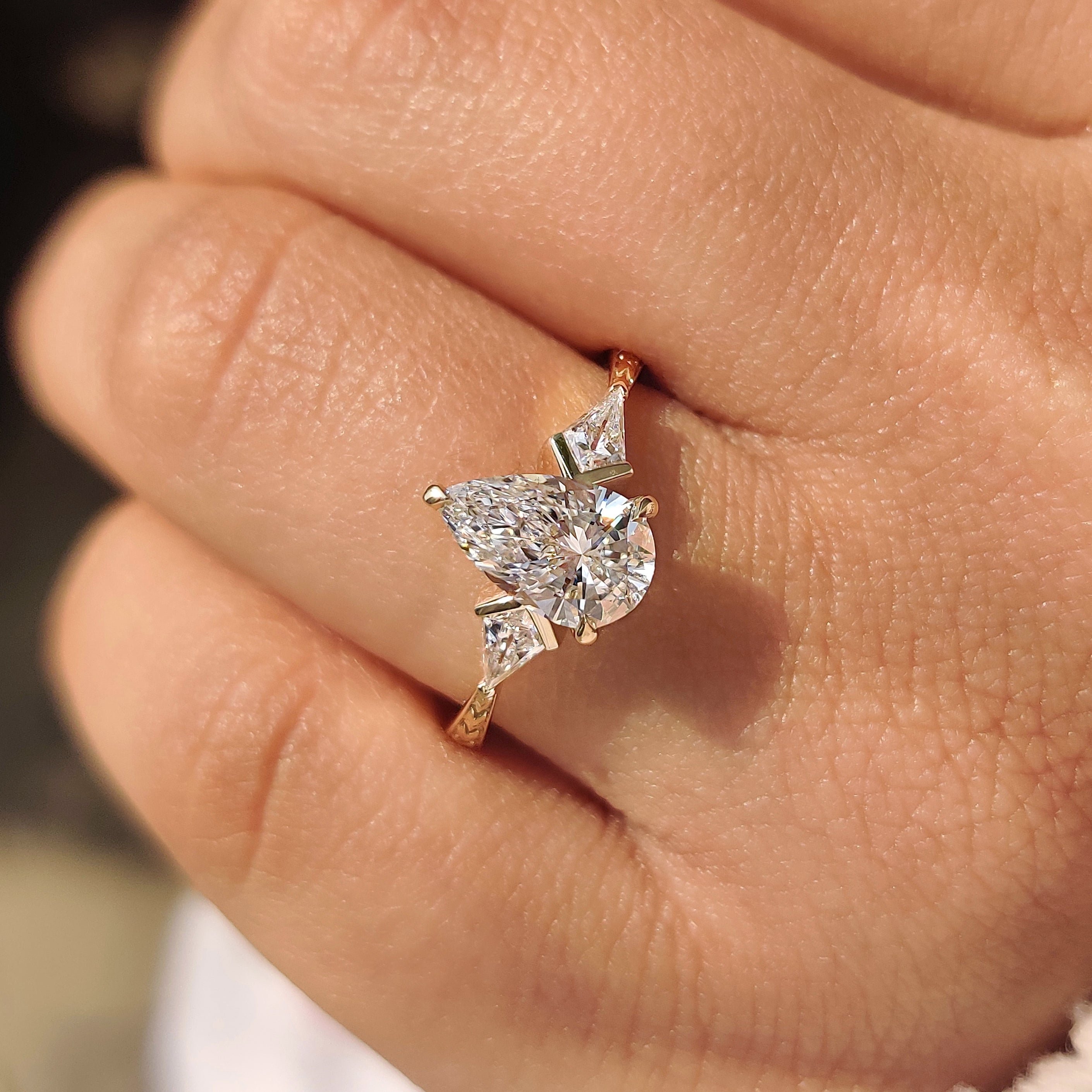 Art deco pear diamond ring with three claw prongs.
