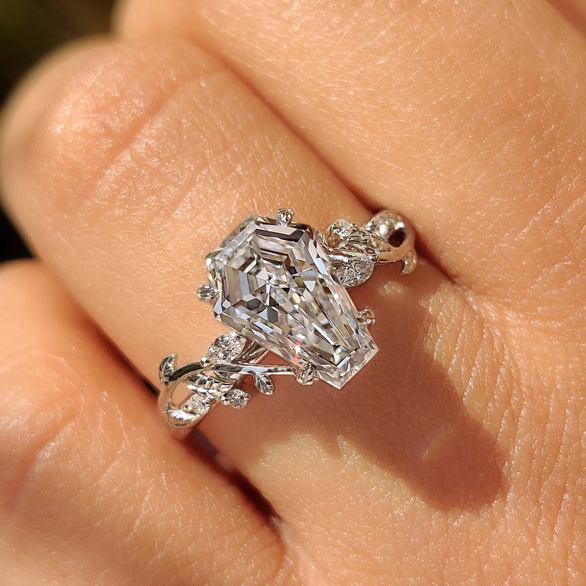 Coffin cut diamond ring with four leaf shape prongs.

